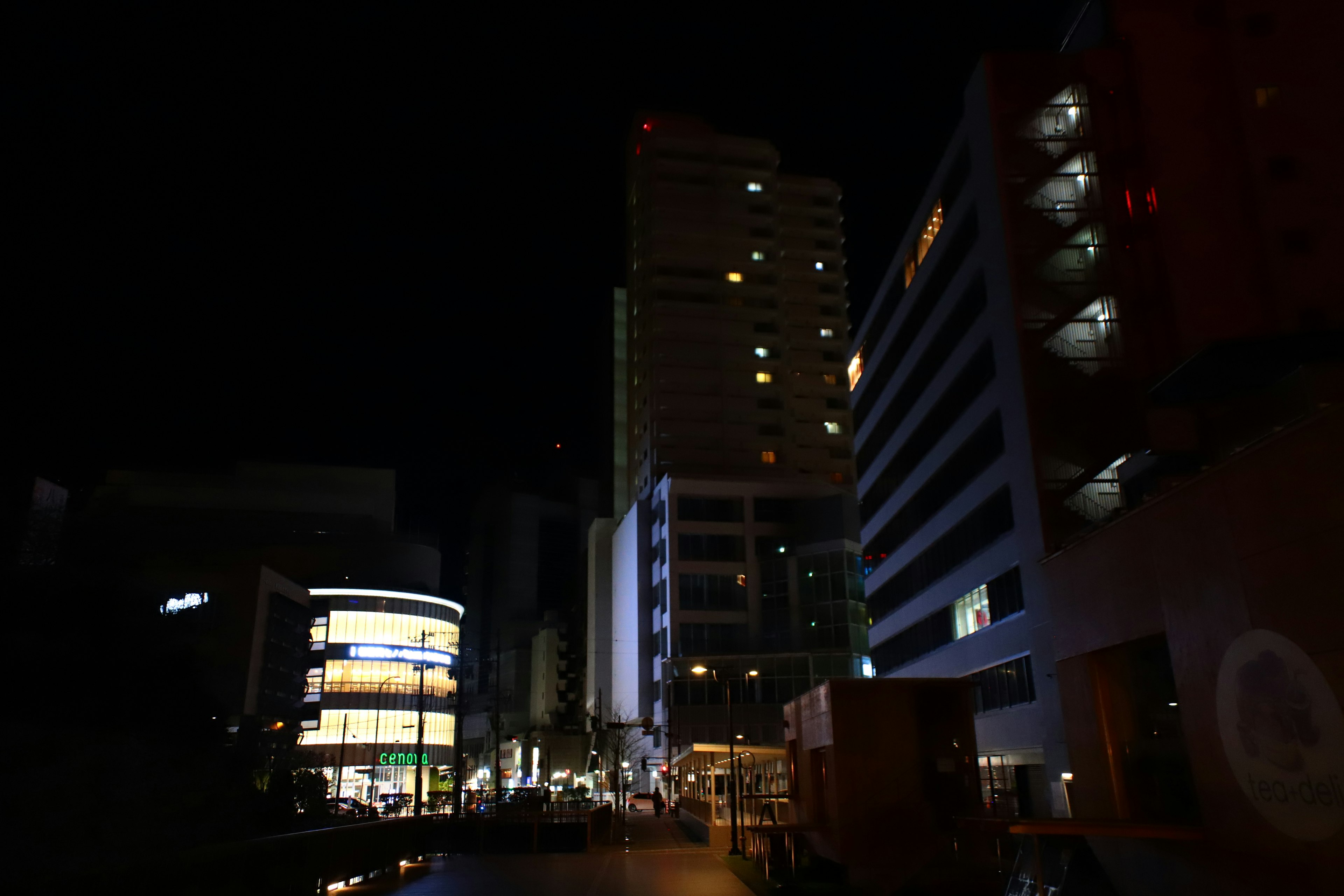 Night cityscape featuring tall buildings and bright signage