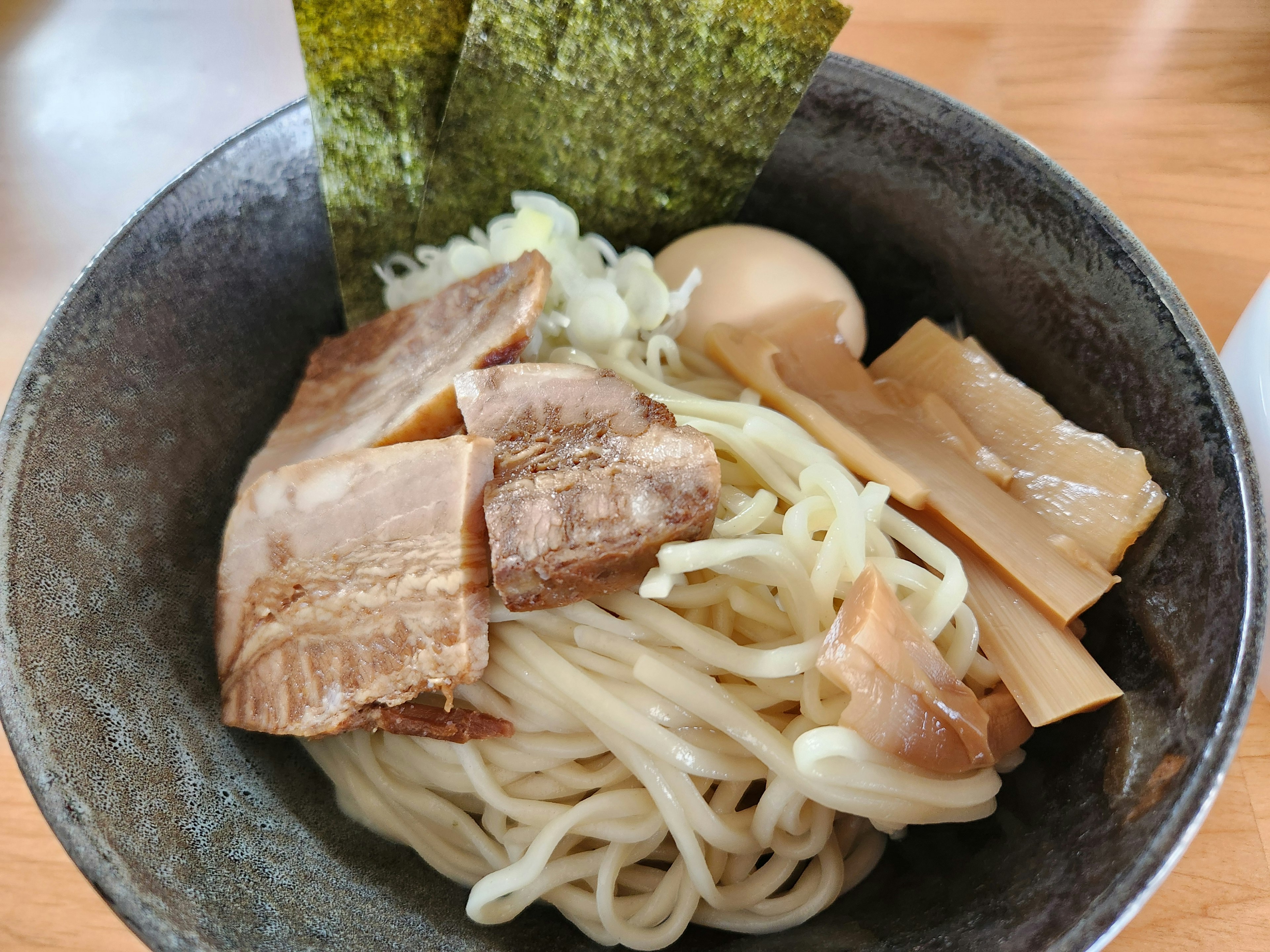 Ciotola di noodles ramen freddi con chashu, menma, uovo sodo e nori