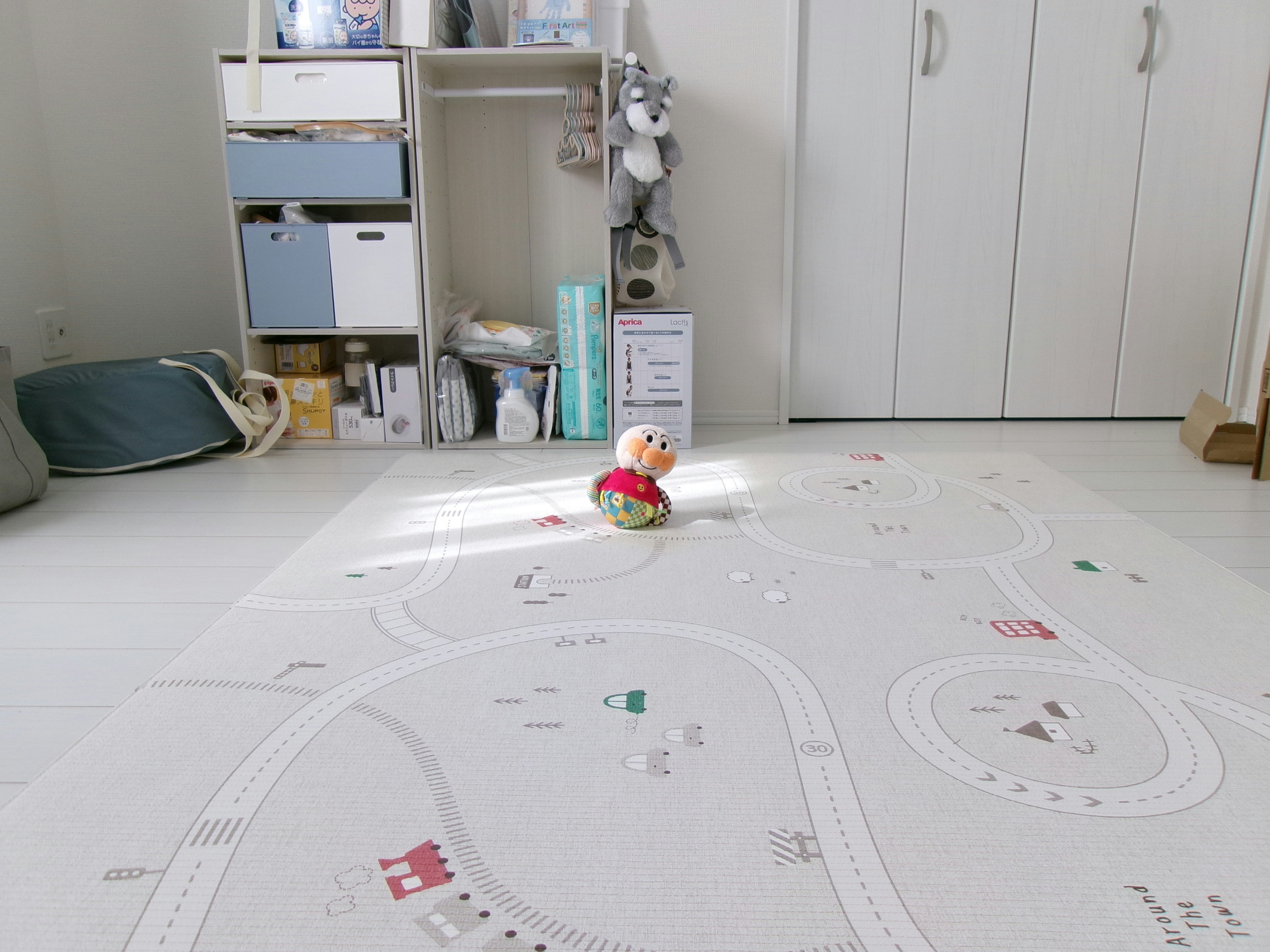 Colorful plush toy on a road-patterned rug in a bright room