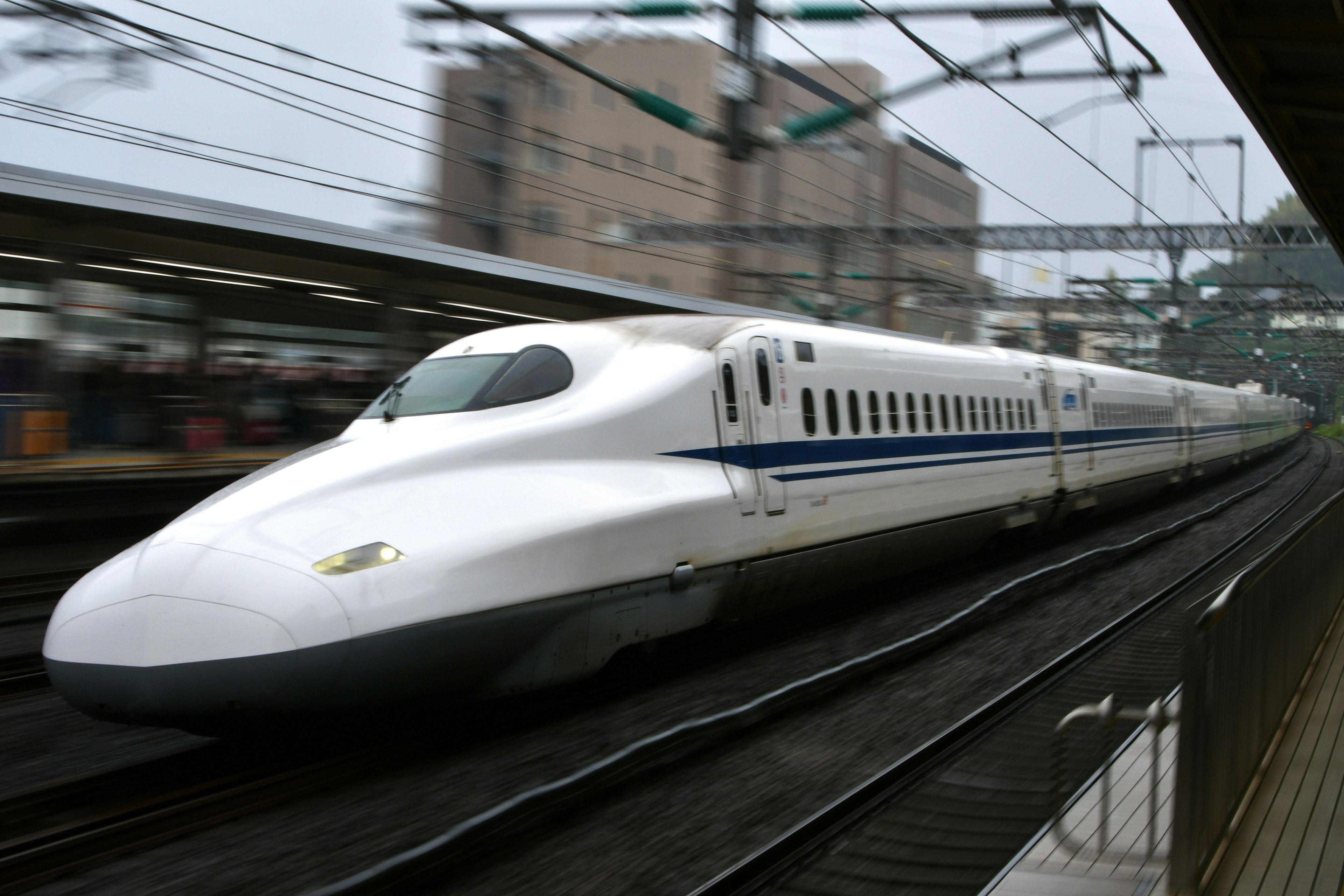 Shinkansen, der schnell an einem Bahnhof vorbeifährt