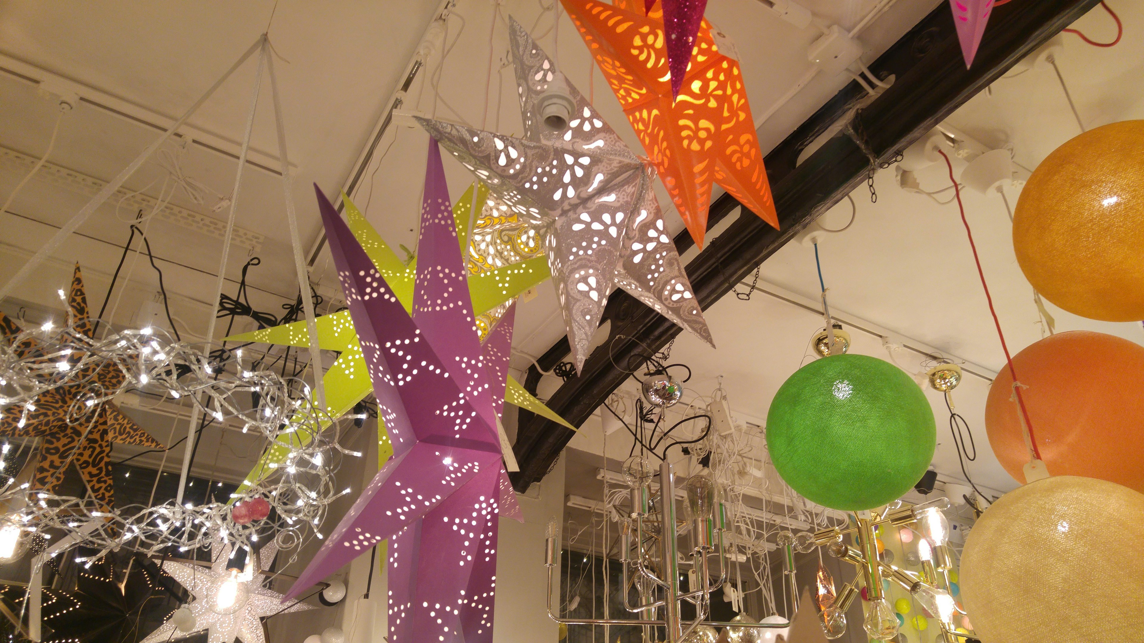 Colorful star-shaped decorations and lights hanging indoors