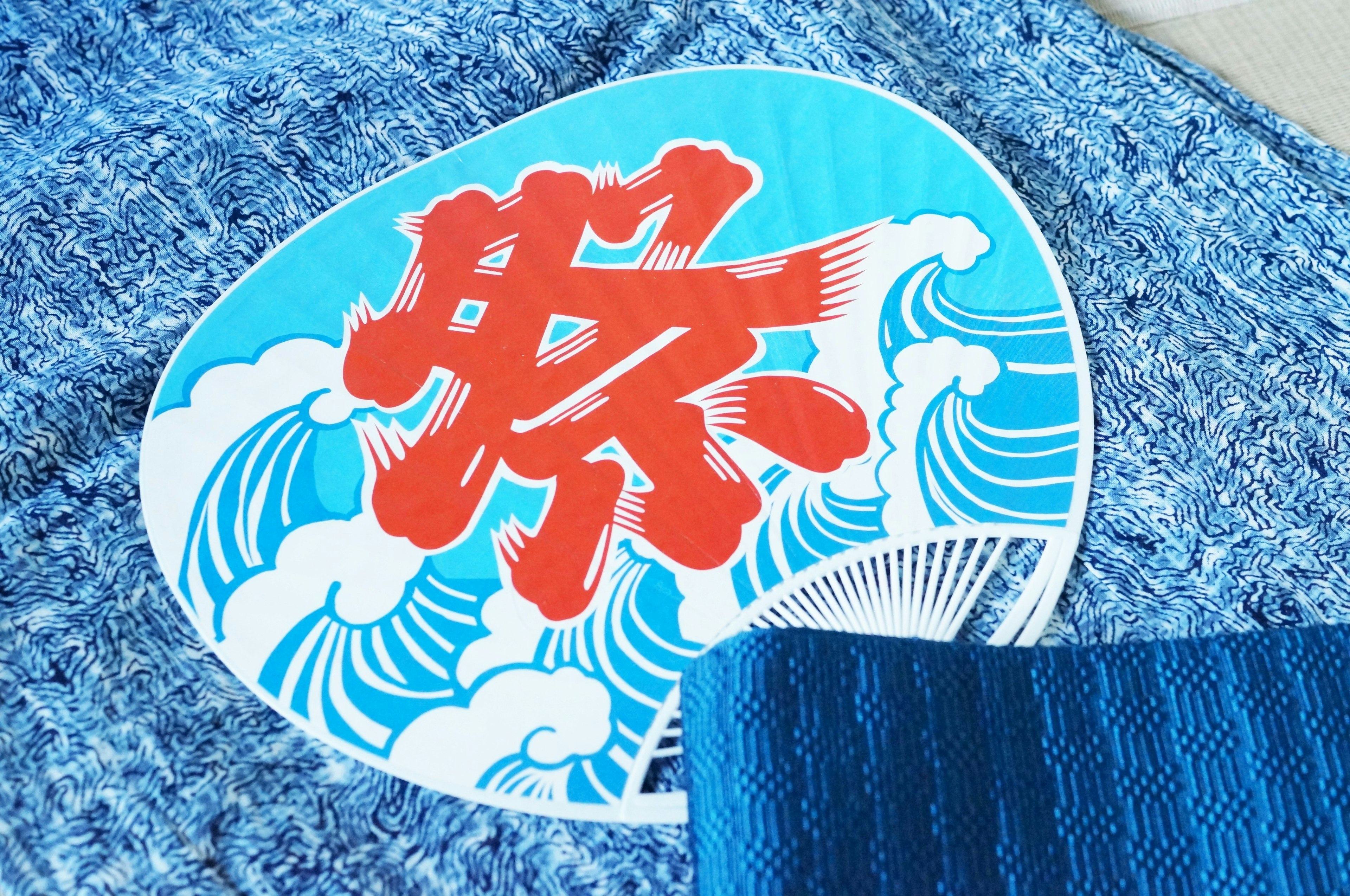 Round sticker with red text and wave design on blue fabric