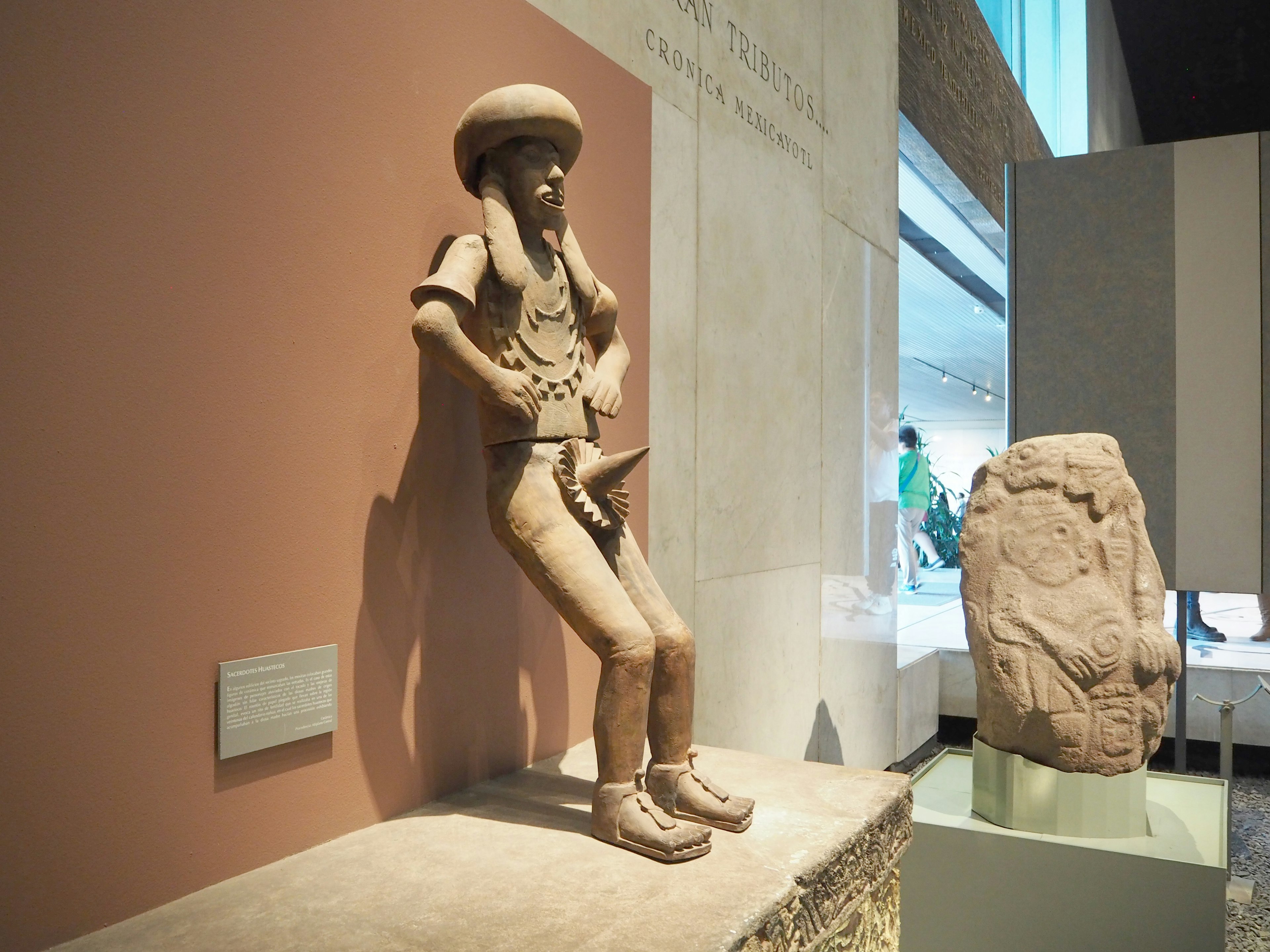 Figure en argile ancienne s'appuyant contre le mur dans un musée