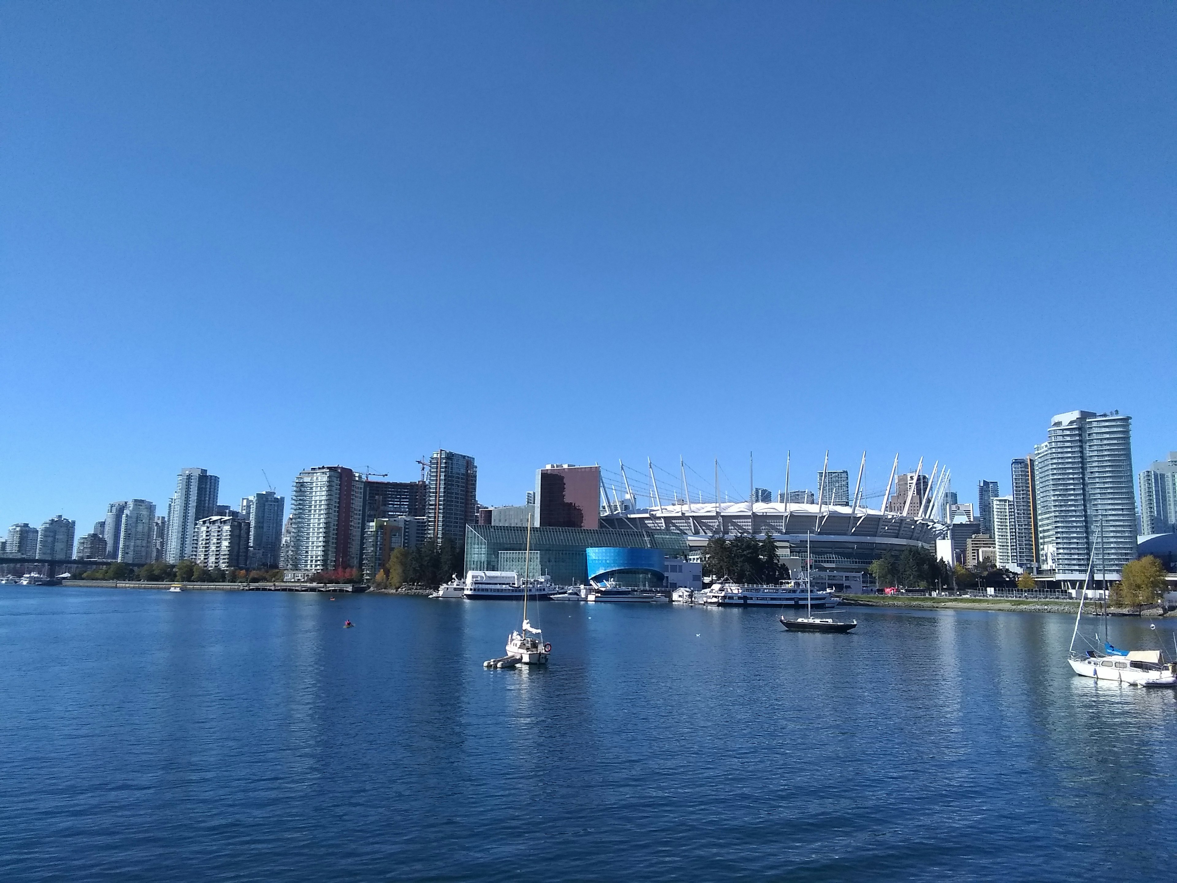 Vancouver skyline with high-rise buildings and stadium under clear blue sky