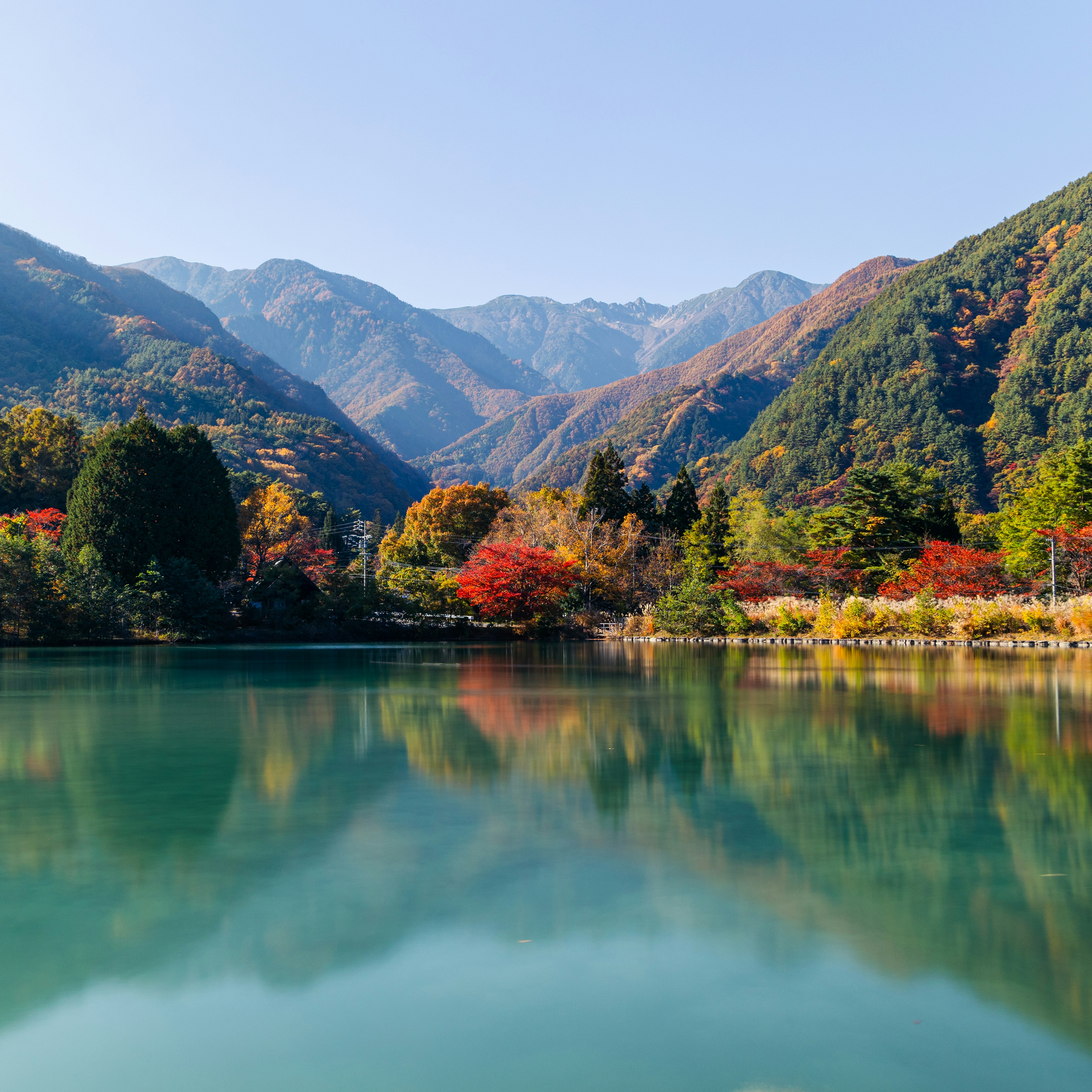 宁静湖泊周围秋叶和山脉的风景