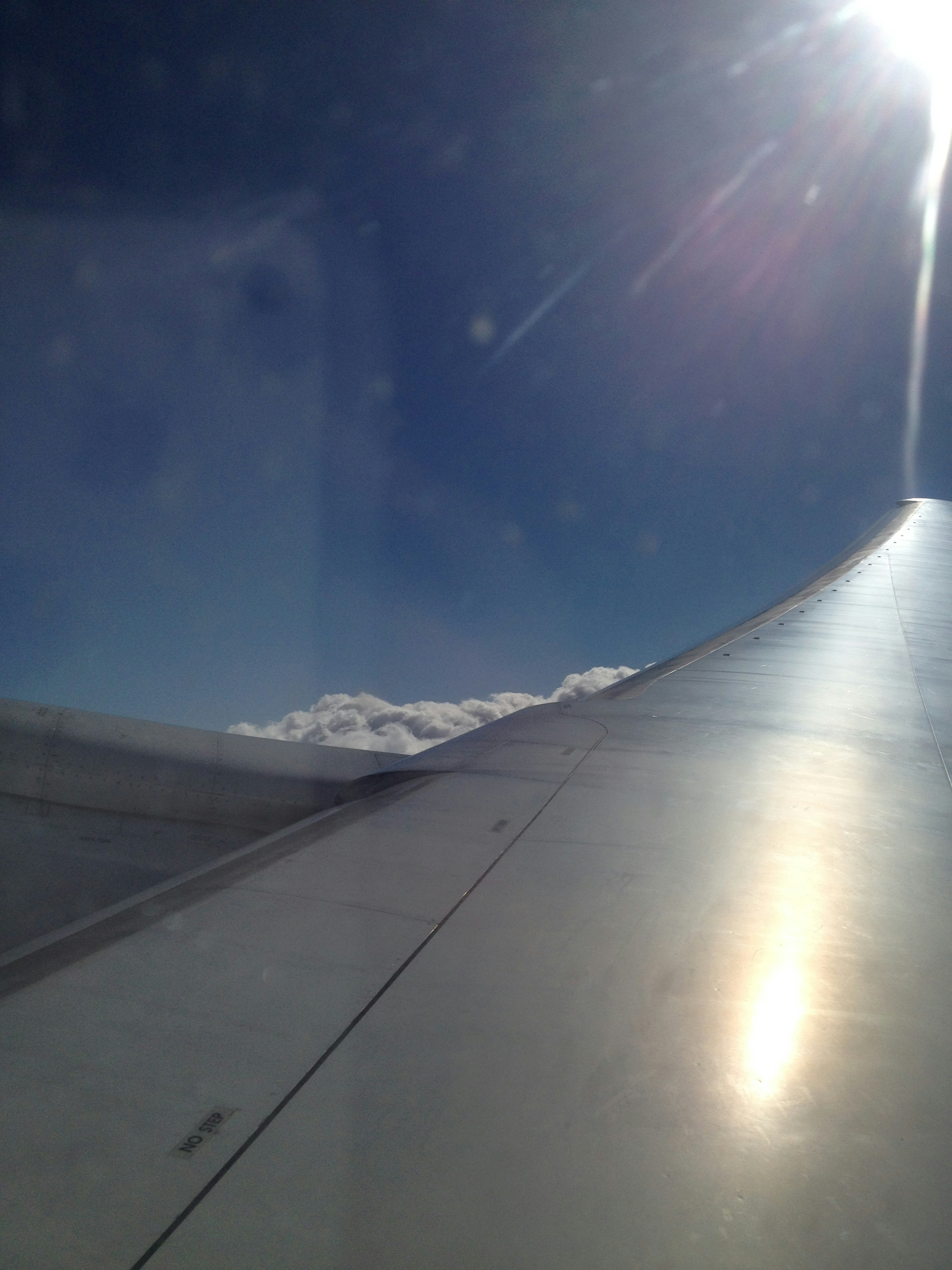 Blick auf einen Flugzeugflügel vor einem blauen Himmel