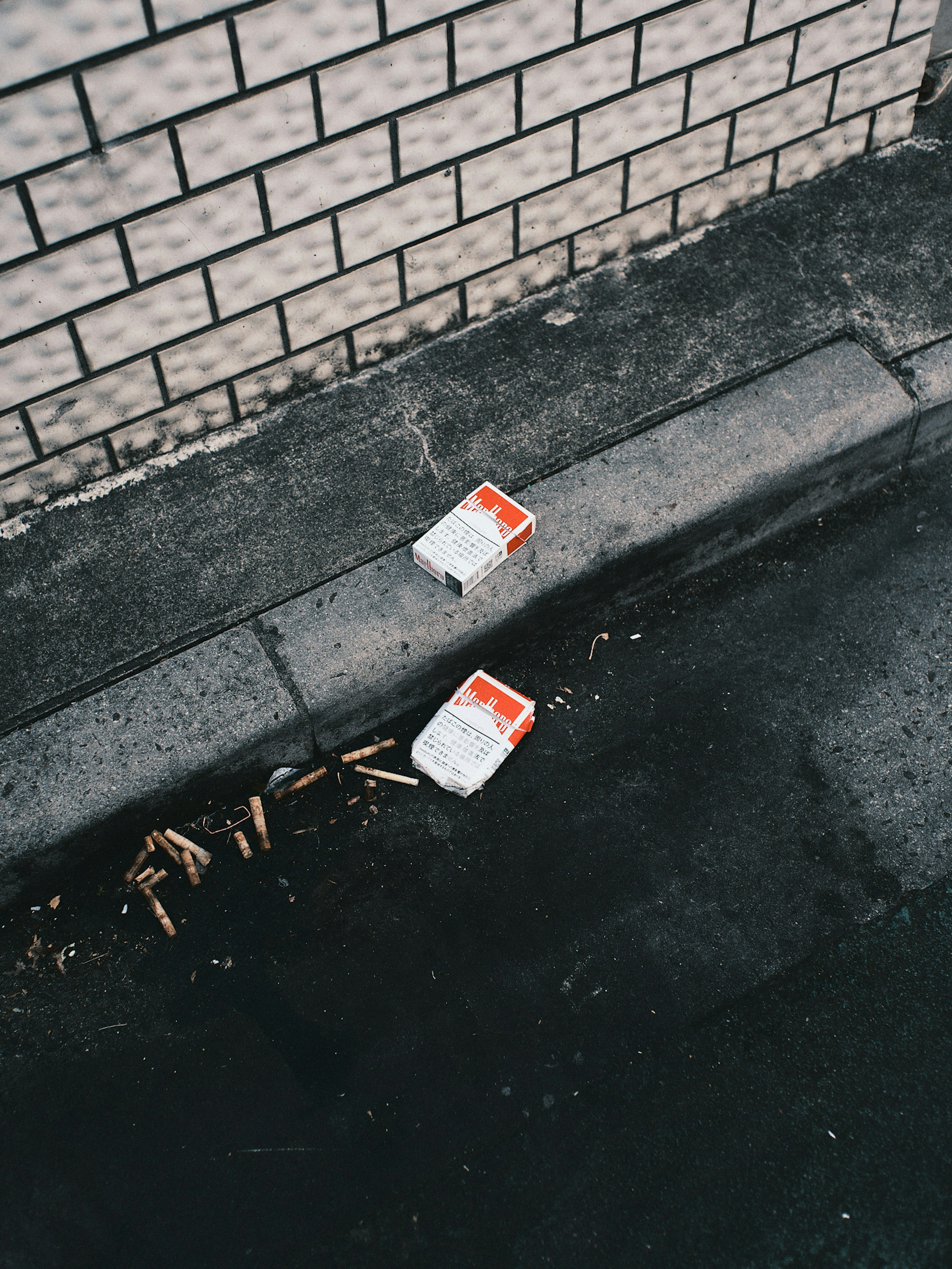 White containers discarded on a street curb surrounded by debris