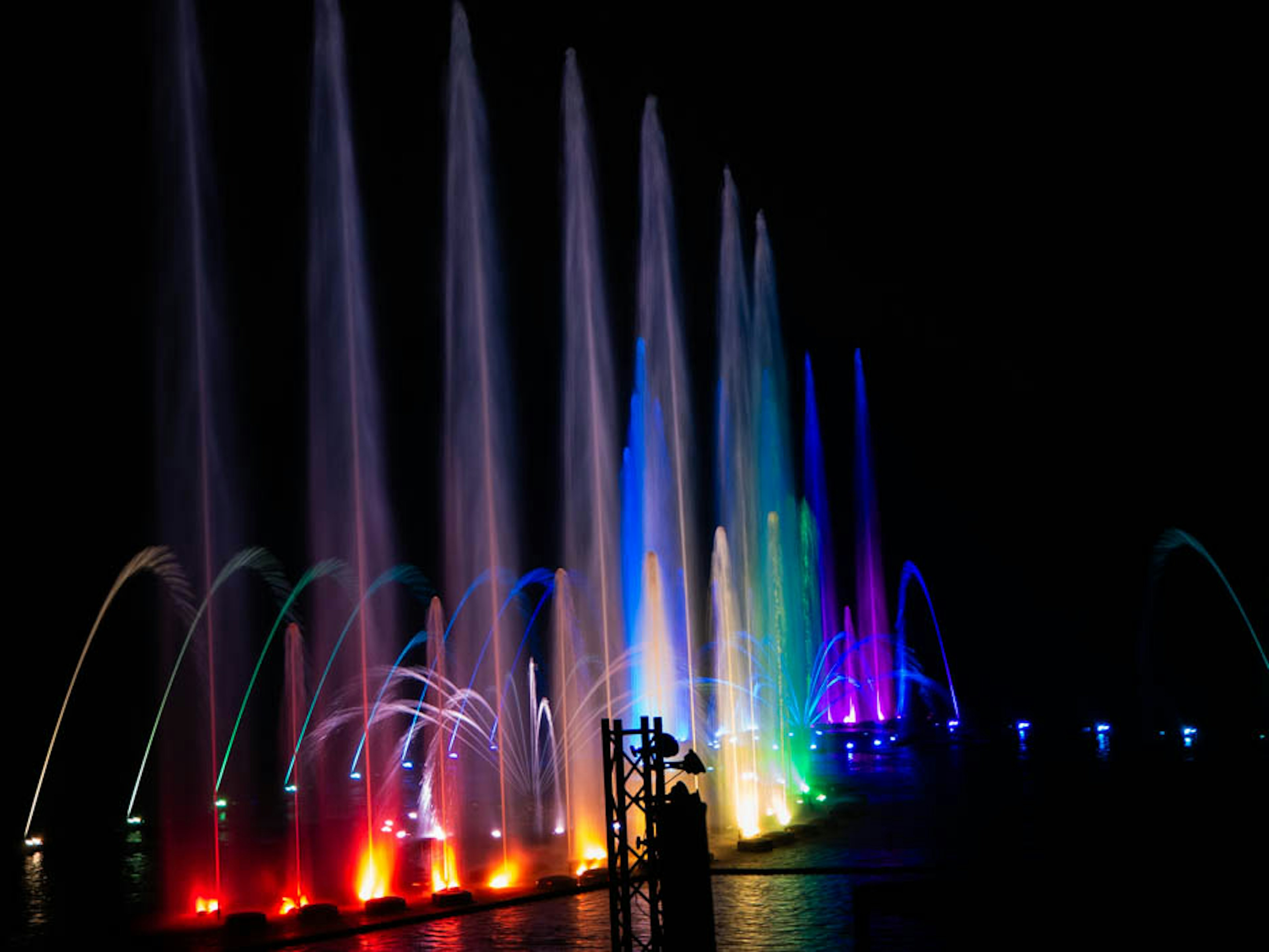 Spectacle de fontaines la nuit avec des jets d'eau colorés