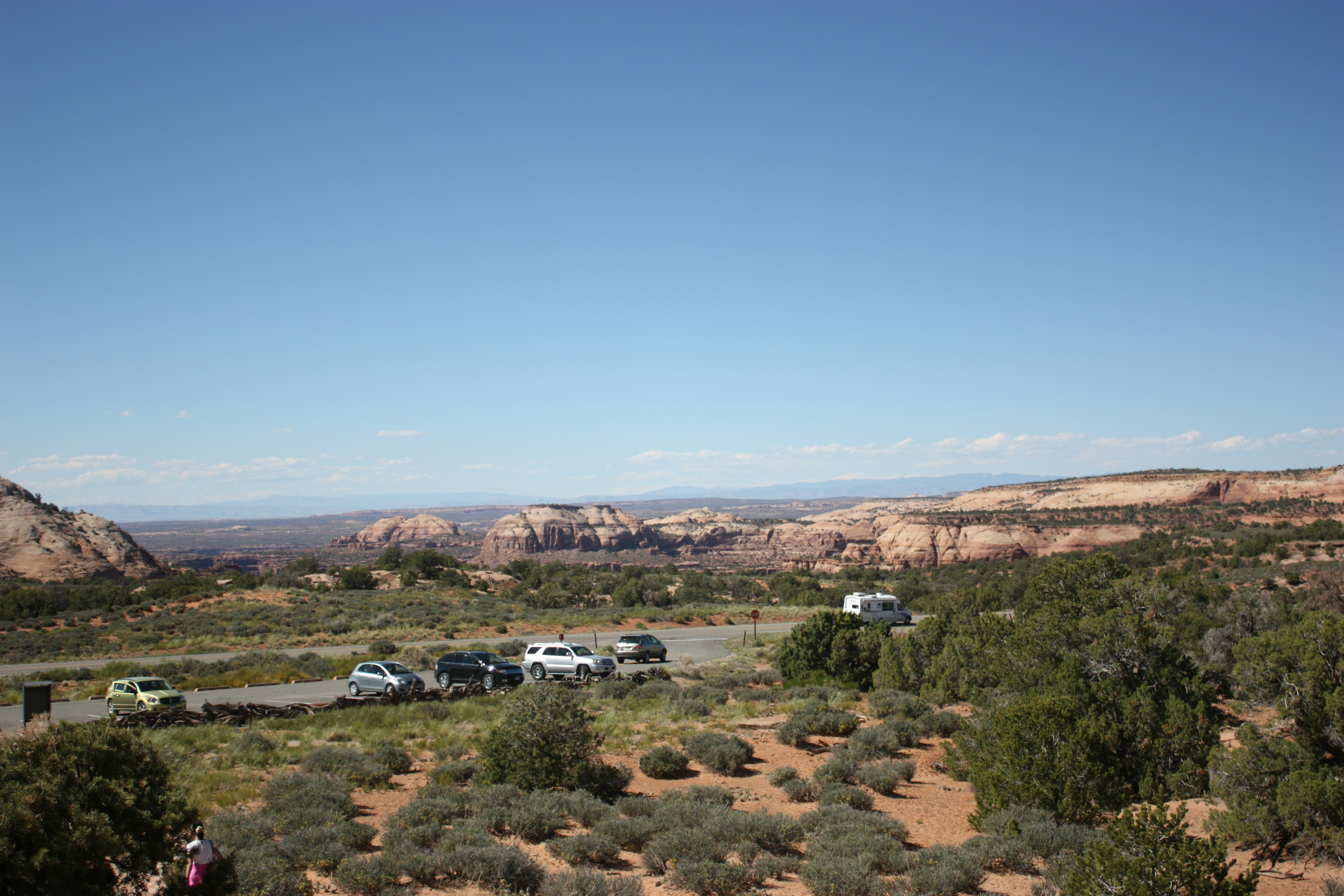 Expansive landscape with parked cars in the foreground