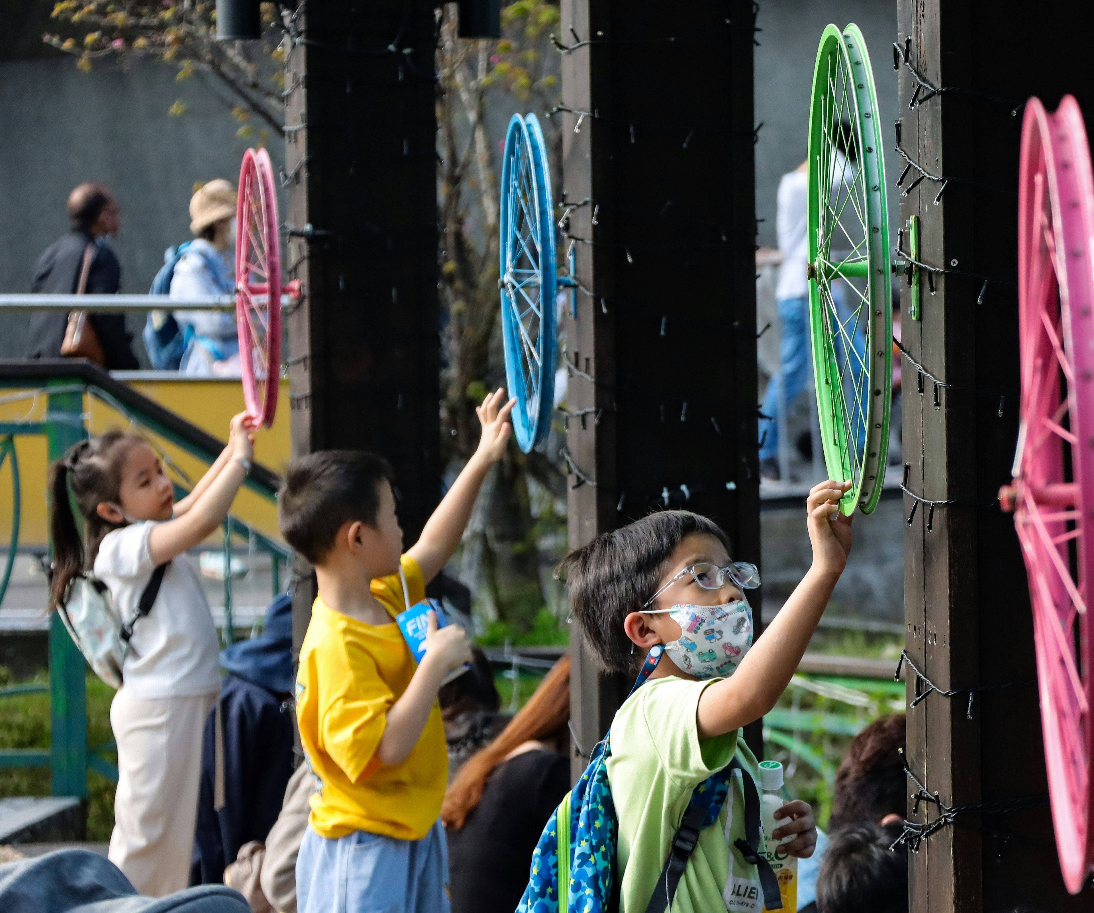 Children interacting with colorful wheels at an outdoor play area