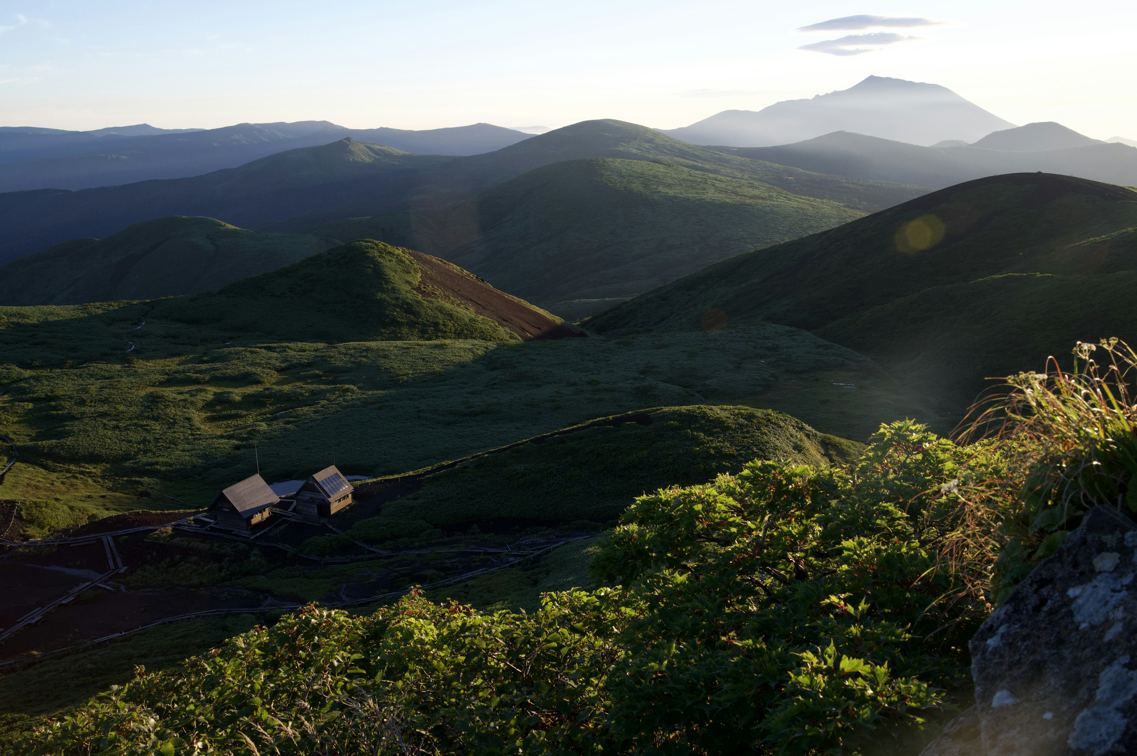 Vista panoramica di dolci colline verdi con una piccola casa tra di esse