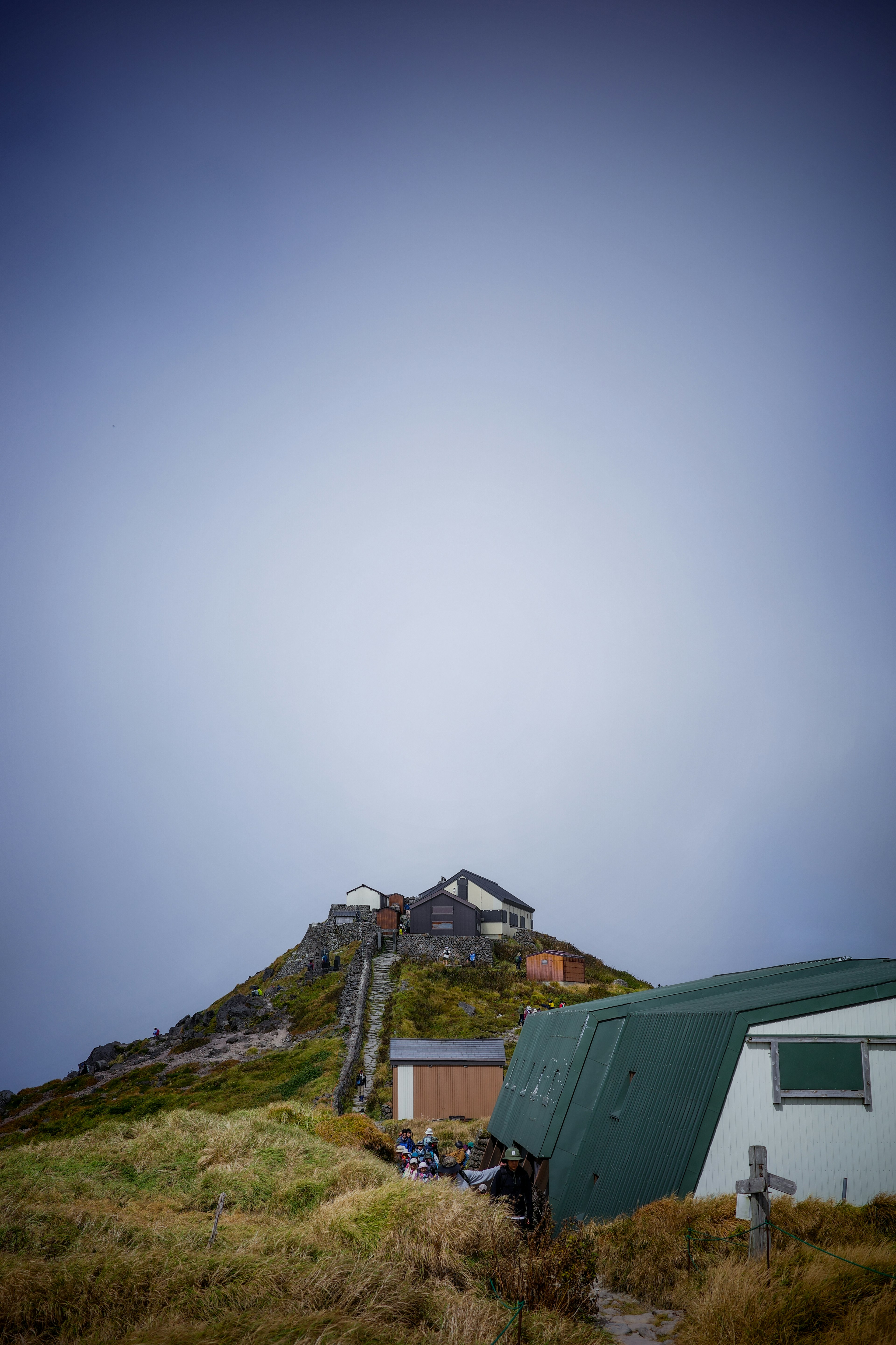 Eine Hütte auf einem Hügel mit umgebendem grünem Gras