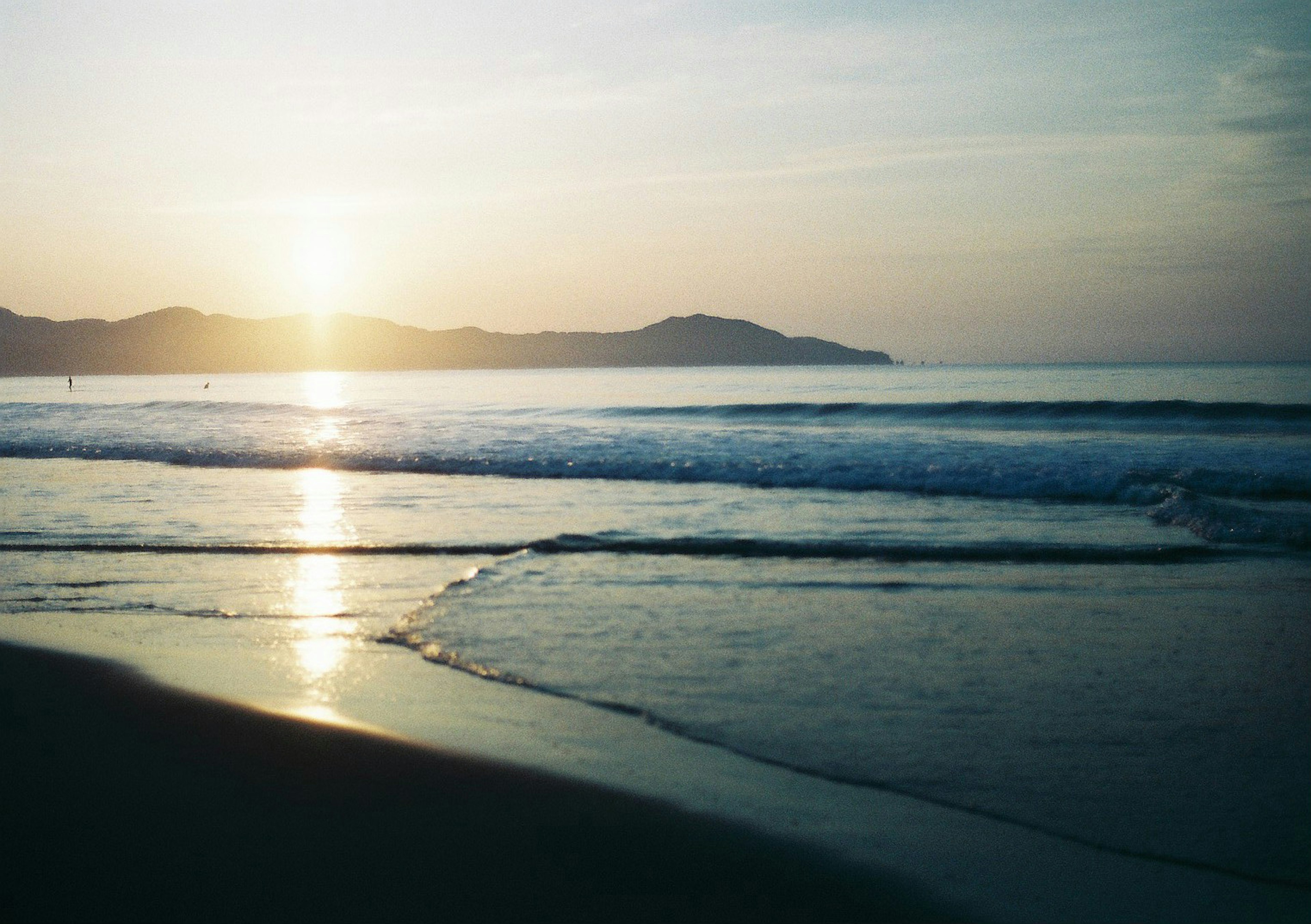 Paesaggio di spiaggia calma con tramonto e onde leggere