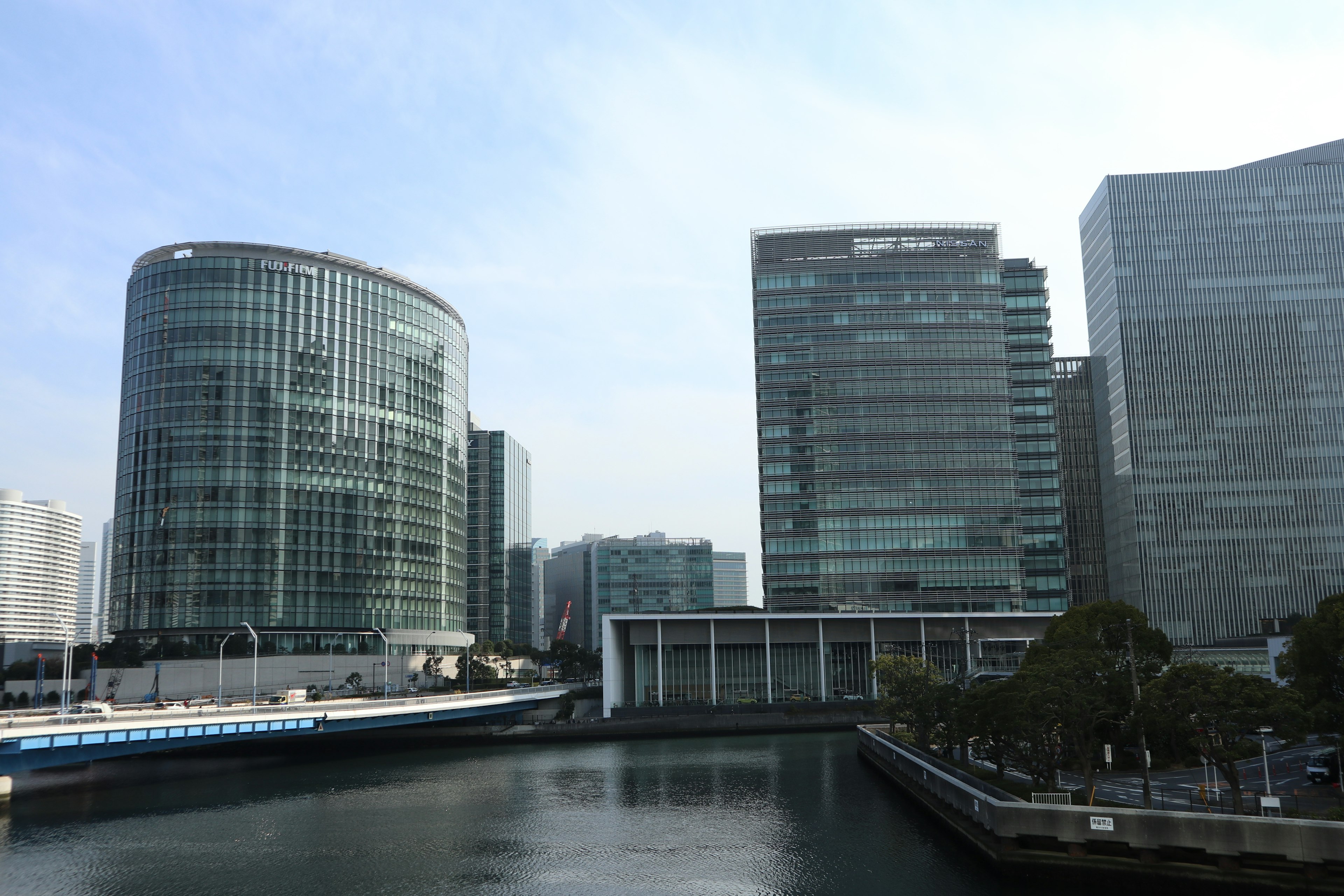 Modern buildings along a river with a clear sky