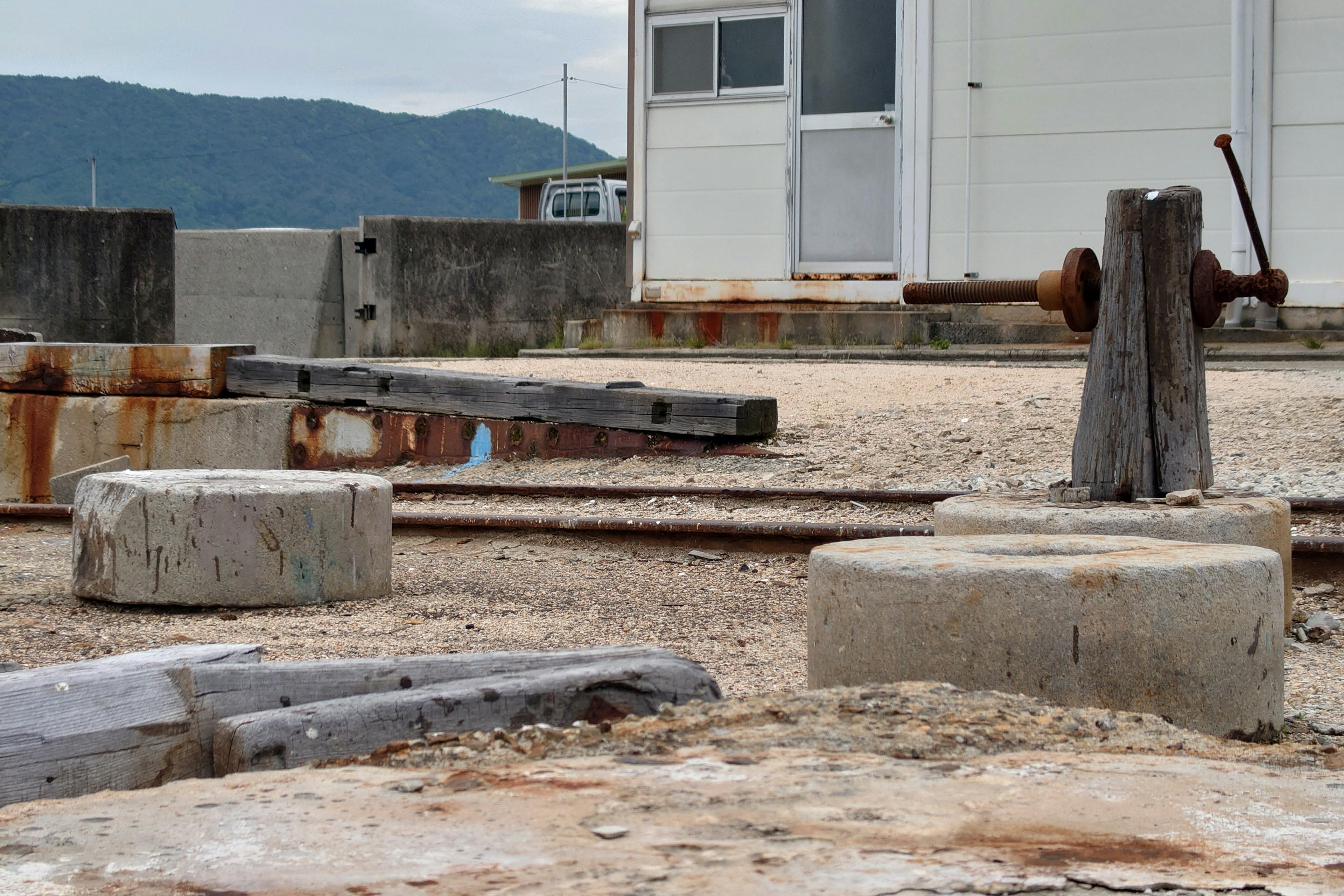 Escena de un viejo puerto mostrando bases de concreto y un aparato de hierro