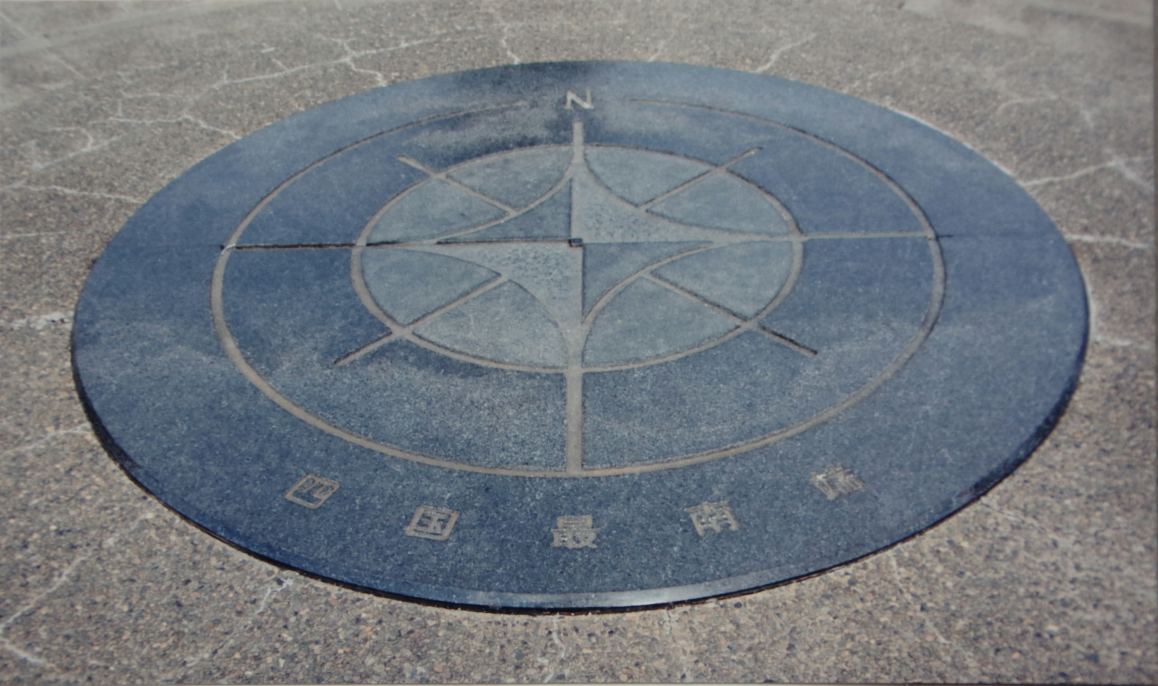 Blue circular stone monument featuring a compass design