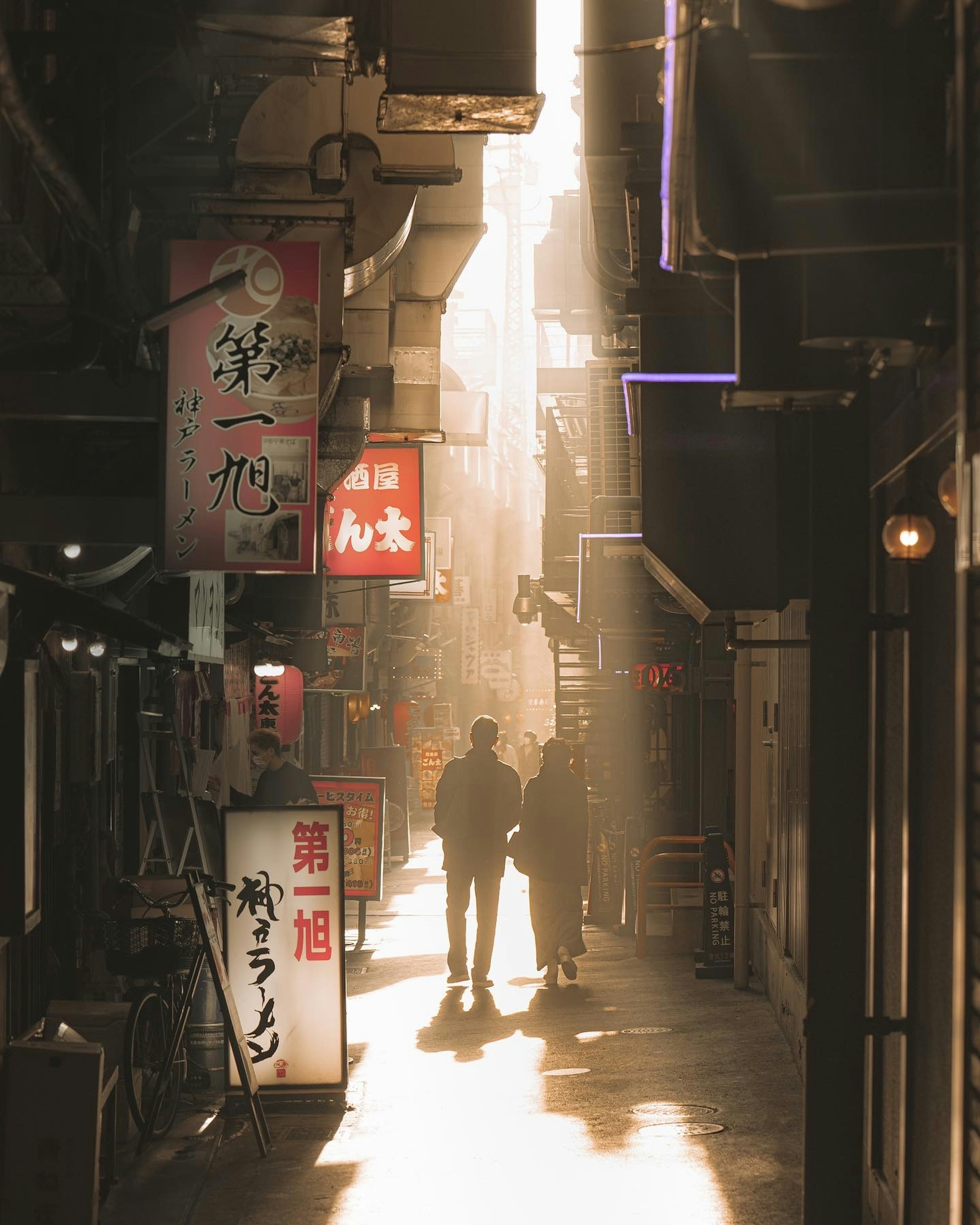 Couple standing in a narrow alley with shop signs and sunlight