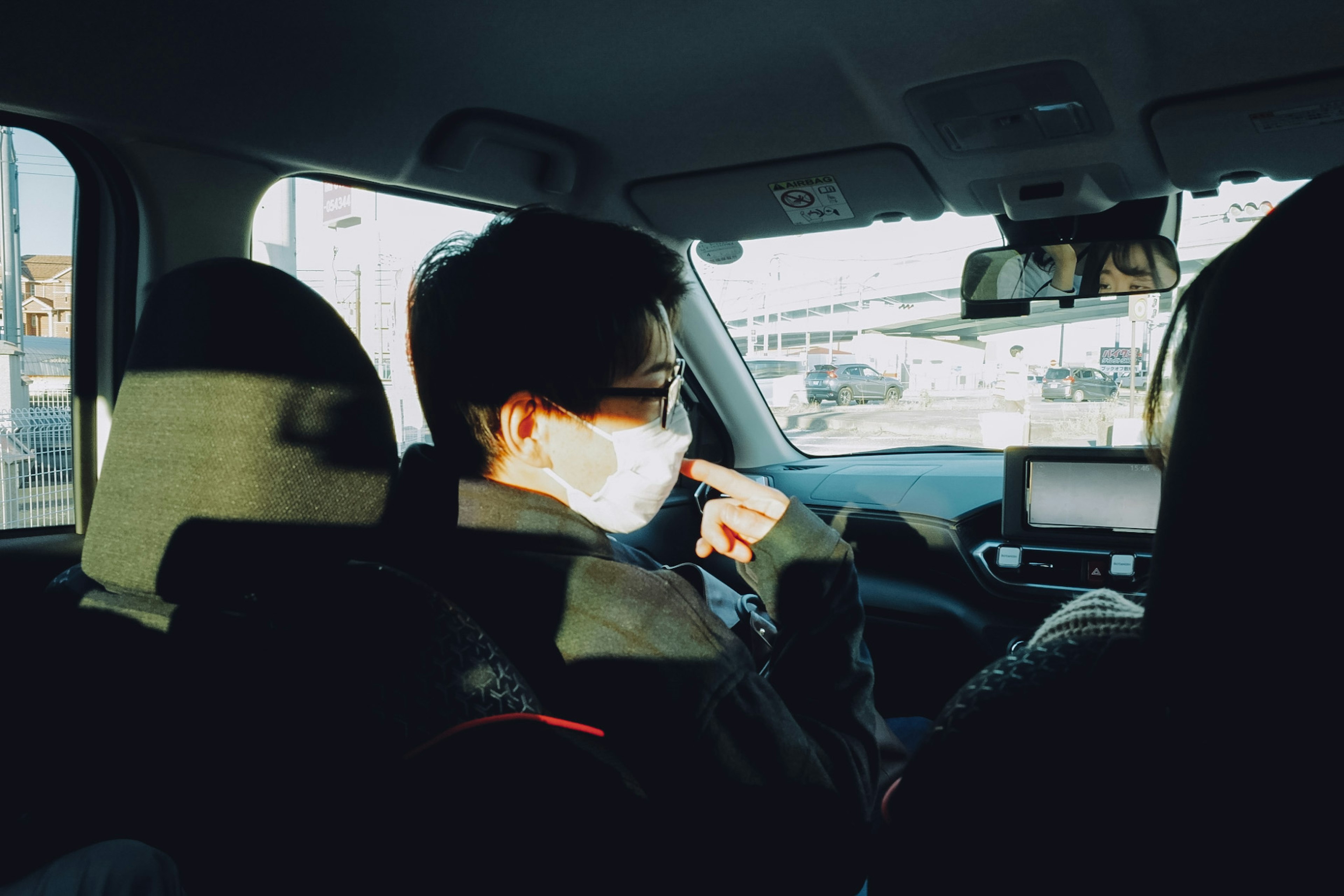 Ein maskierter Mann und eine Frau sitzen auf dem Rücksitz eines Autos