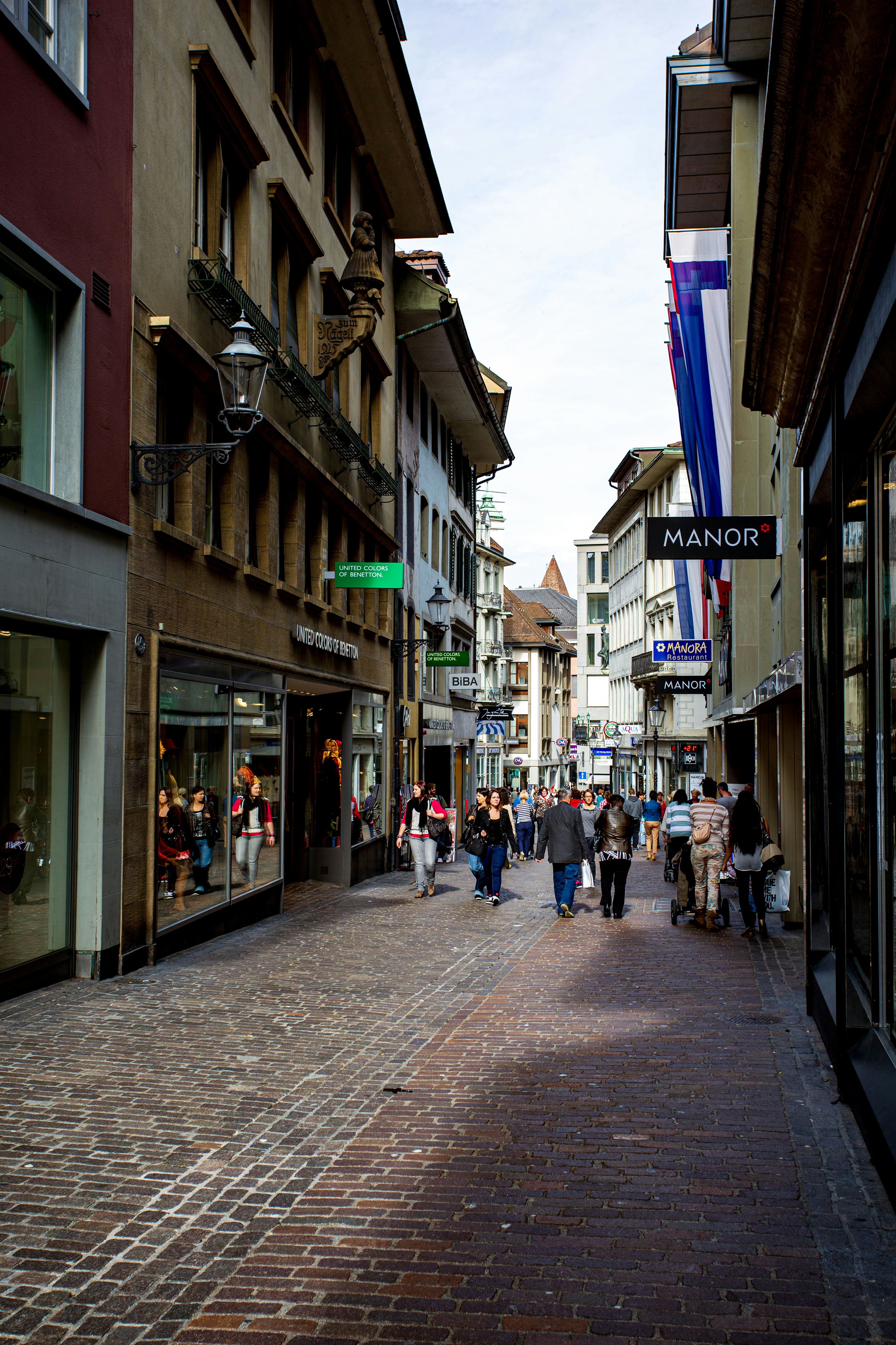 A bustling shopping street scene in a Swiss city