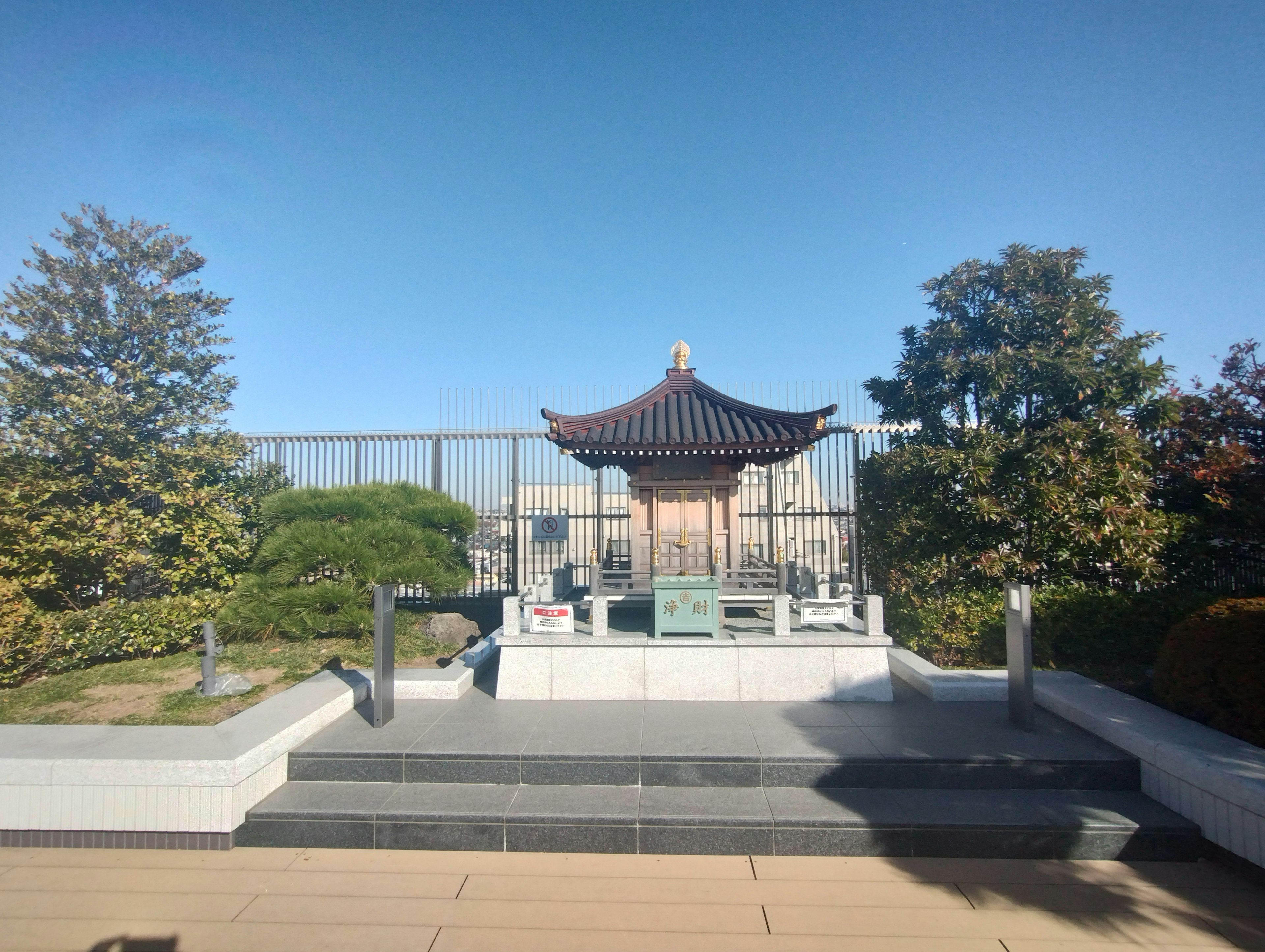 Traditional Chinese-style building in a rooftop garden with greenery