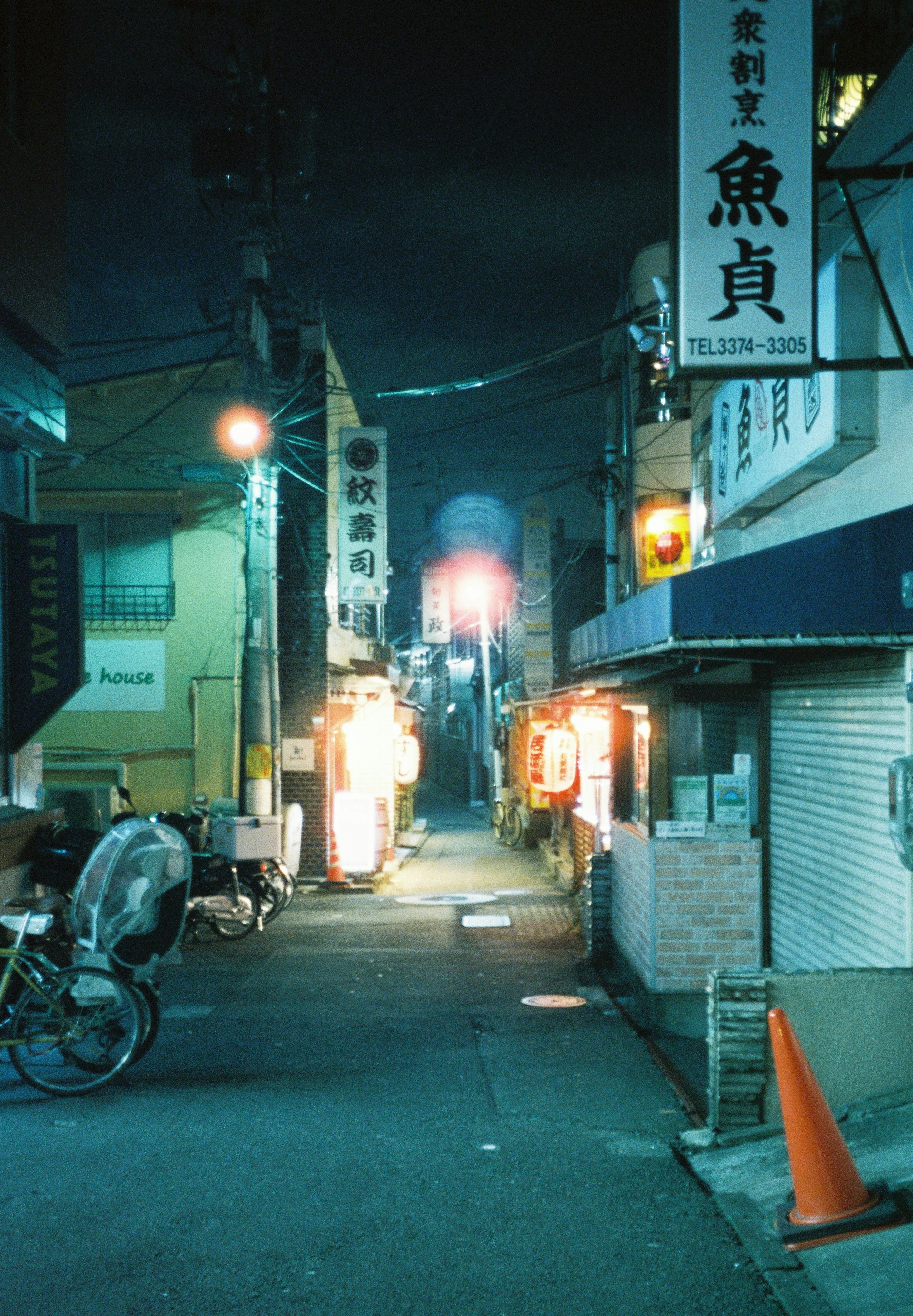 夜の街並みと看板が映る路地