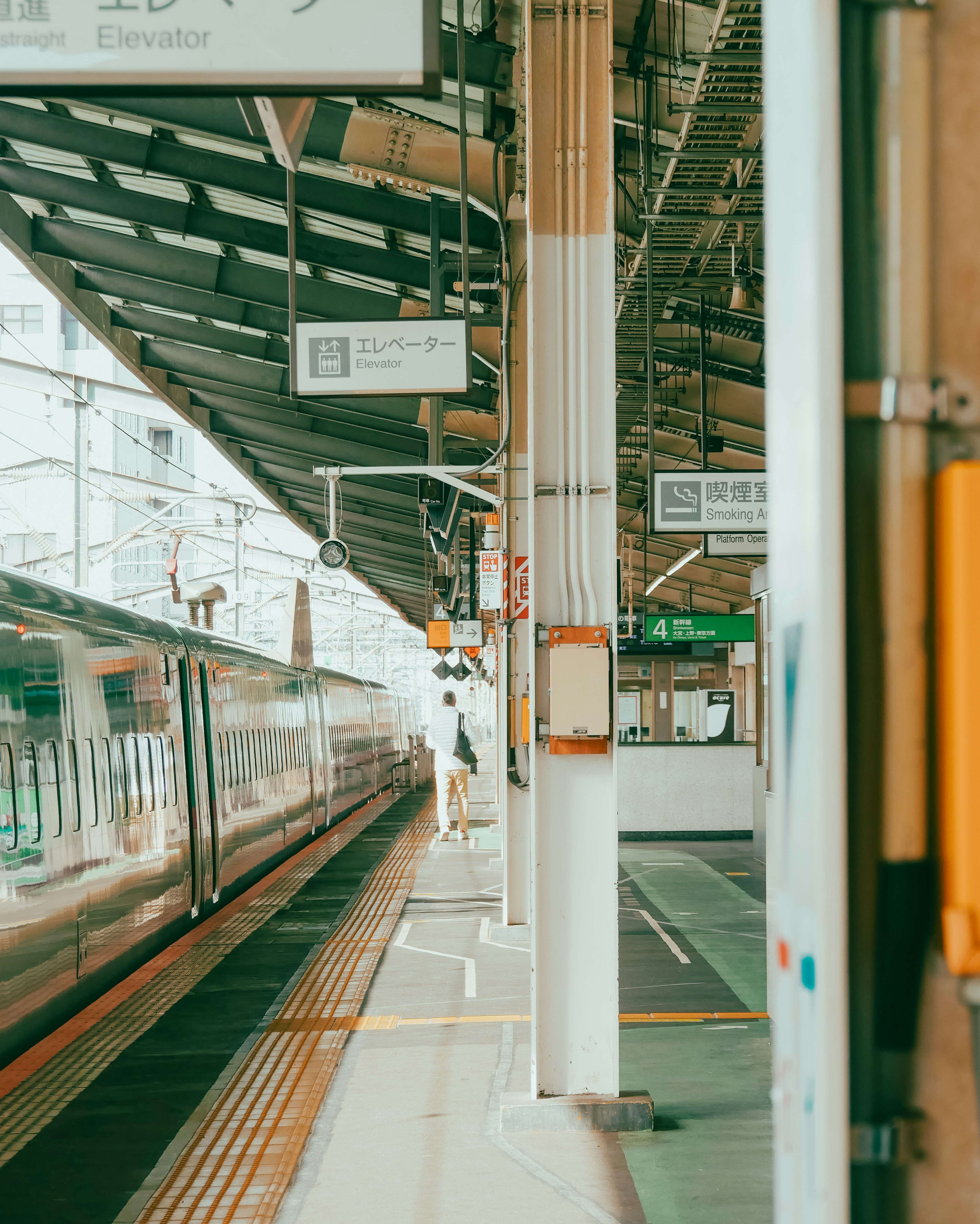 駅のプラットフォームに停車中の電車と人のシルエット