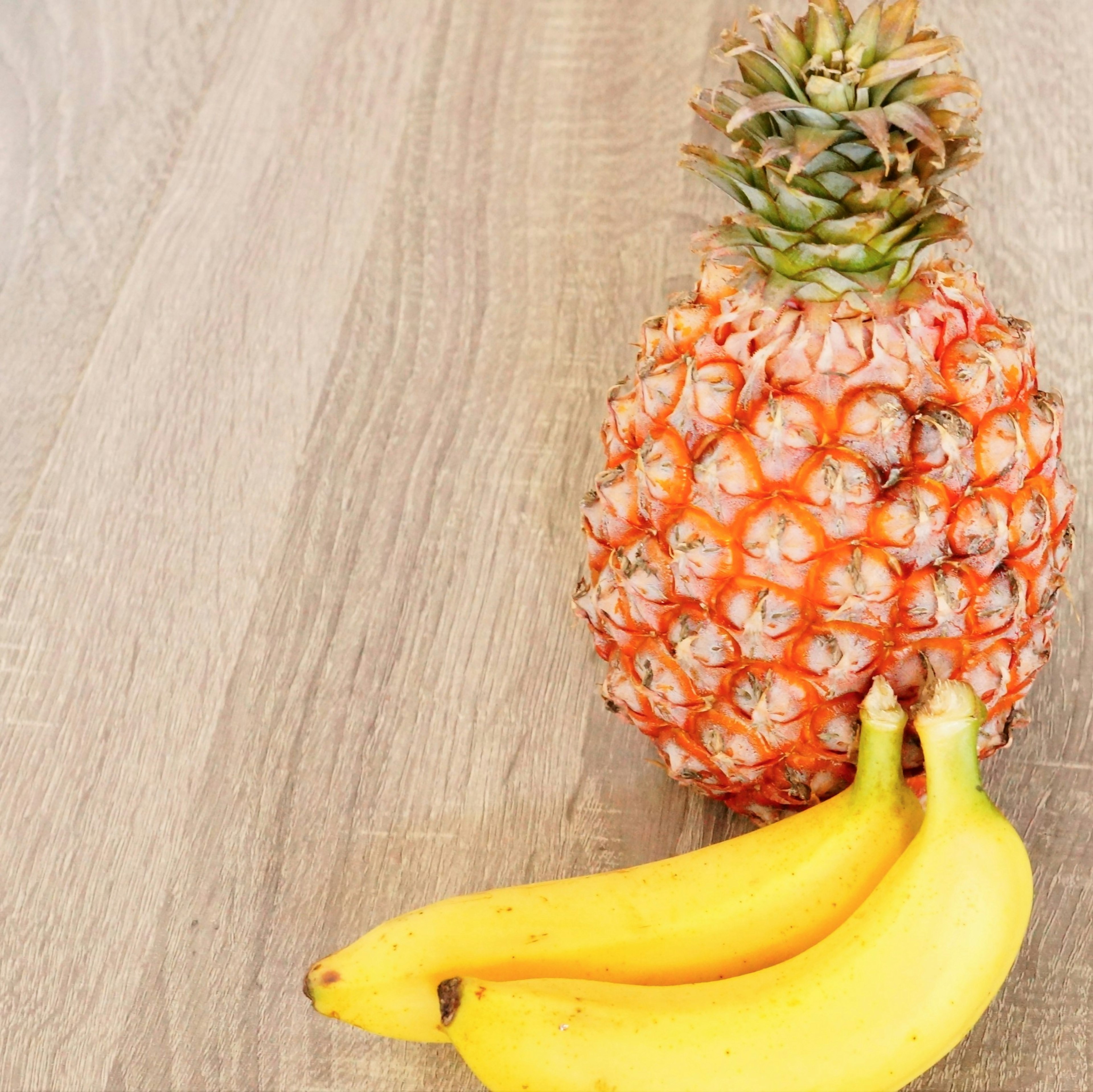 Ananas et bananes sur une table en bois