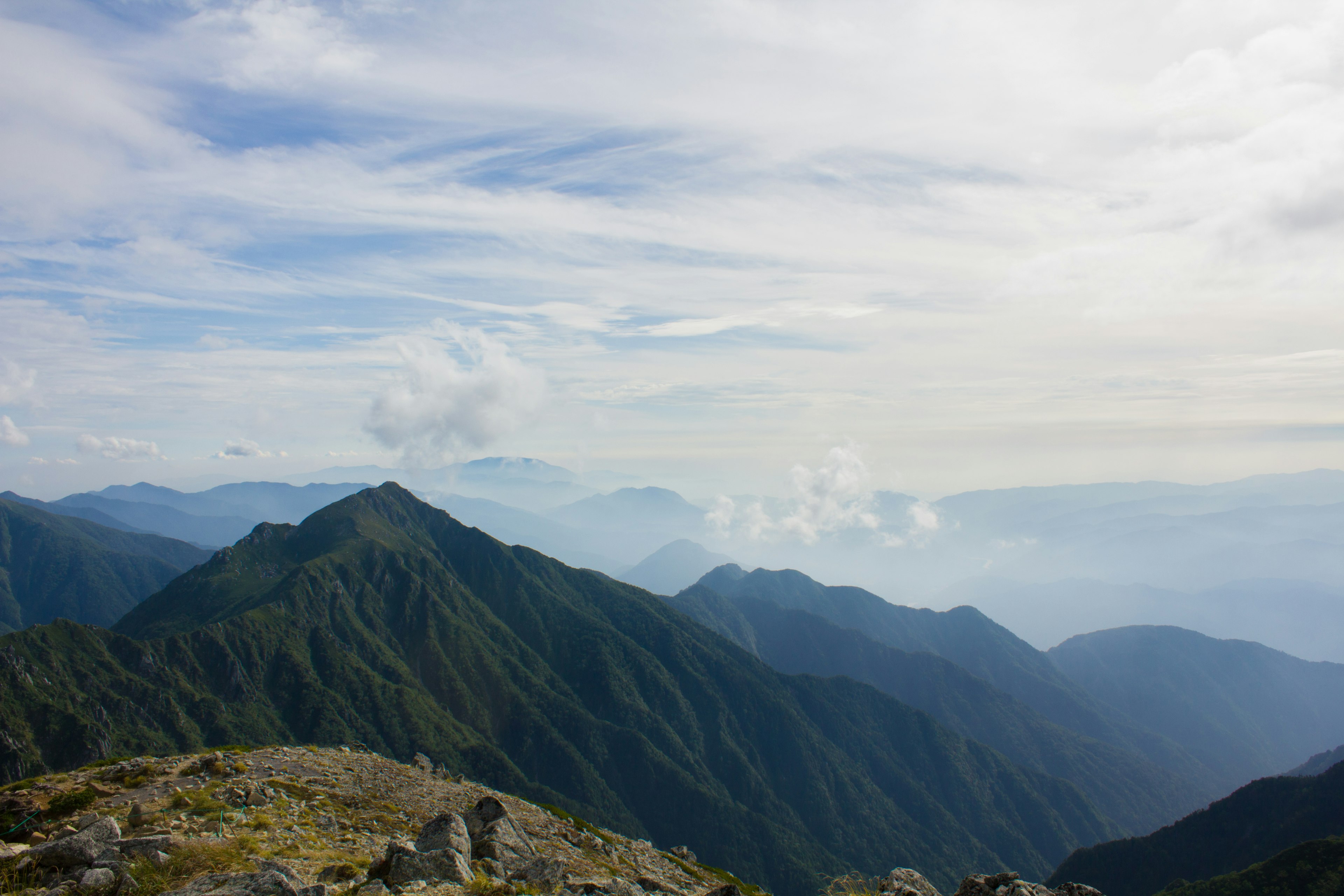 Vista panoramica delle montagne sotto un cielo blu con nuvole