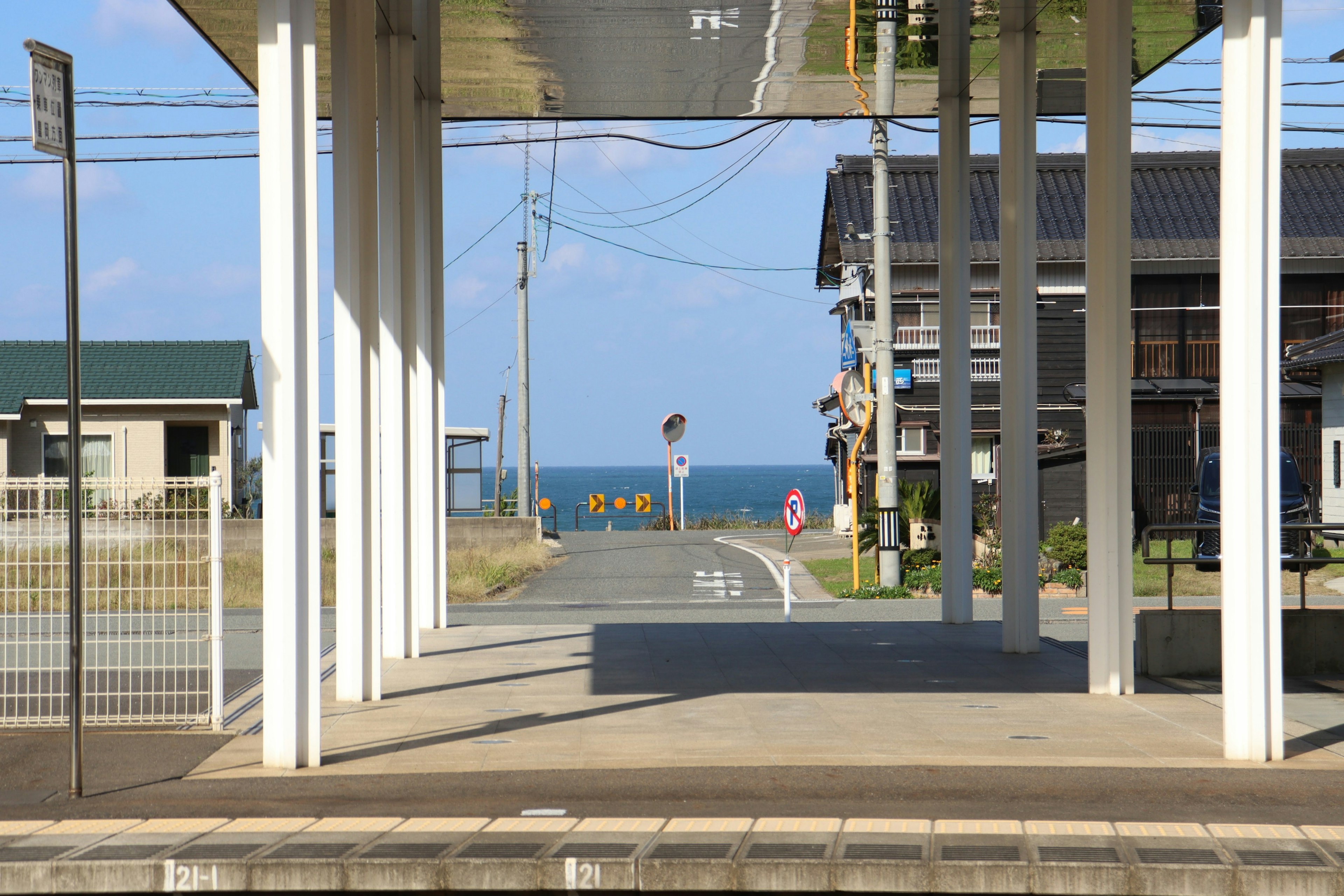 View of a train station platform with the ocean in the background