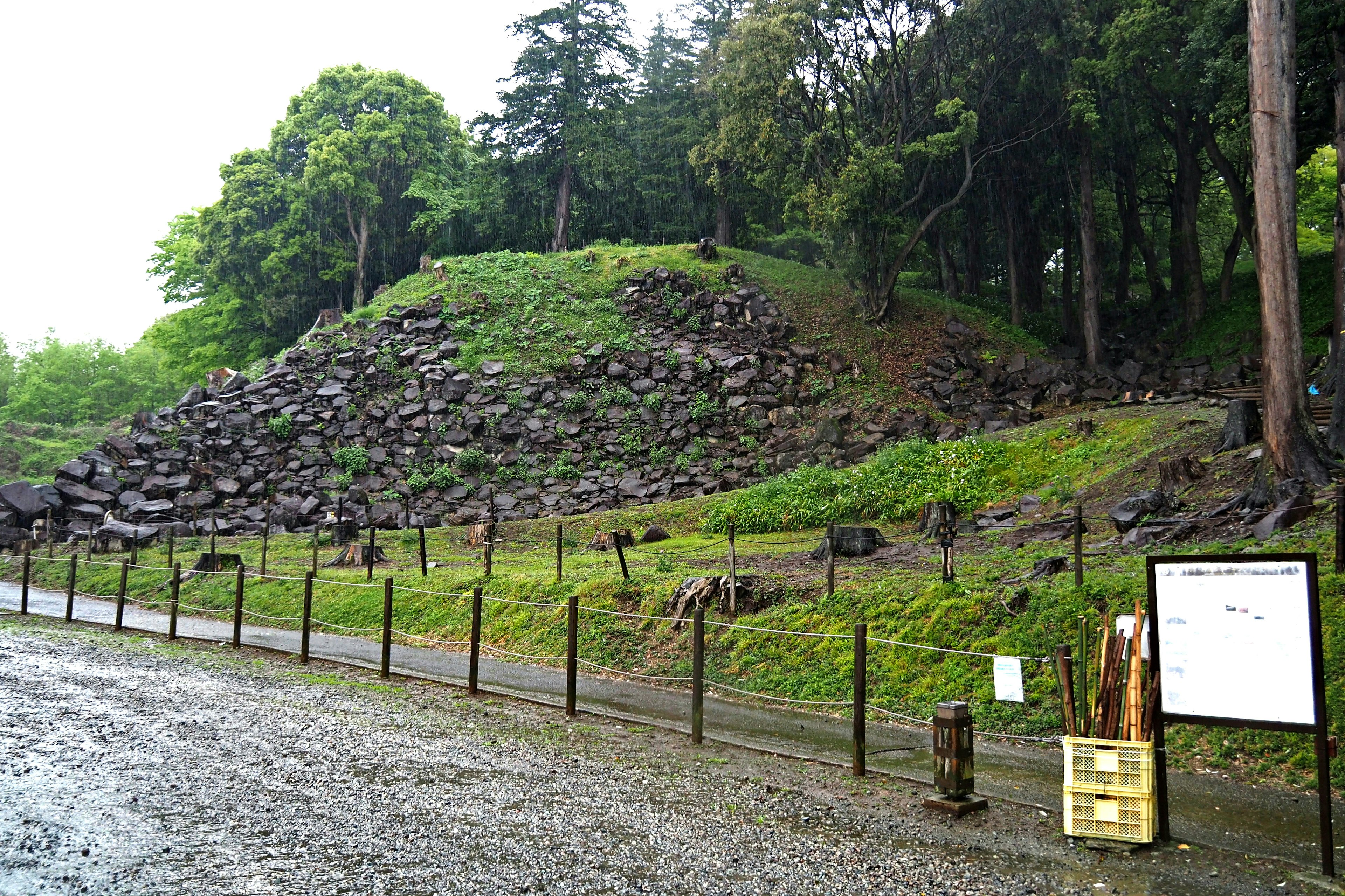 一个被绿色植被和围栏环绕的岩石丘陵风景