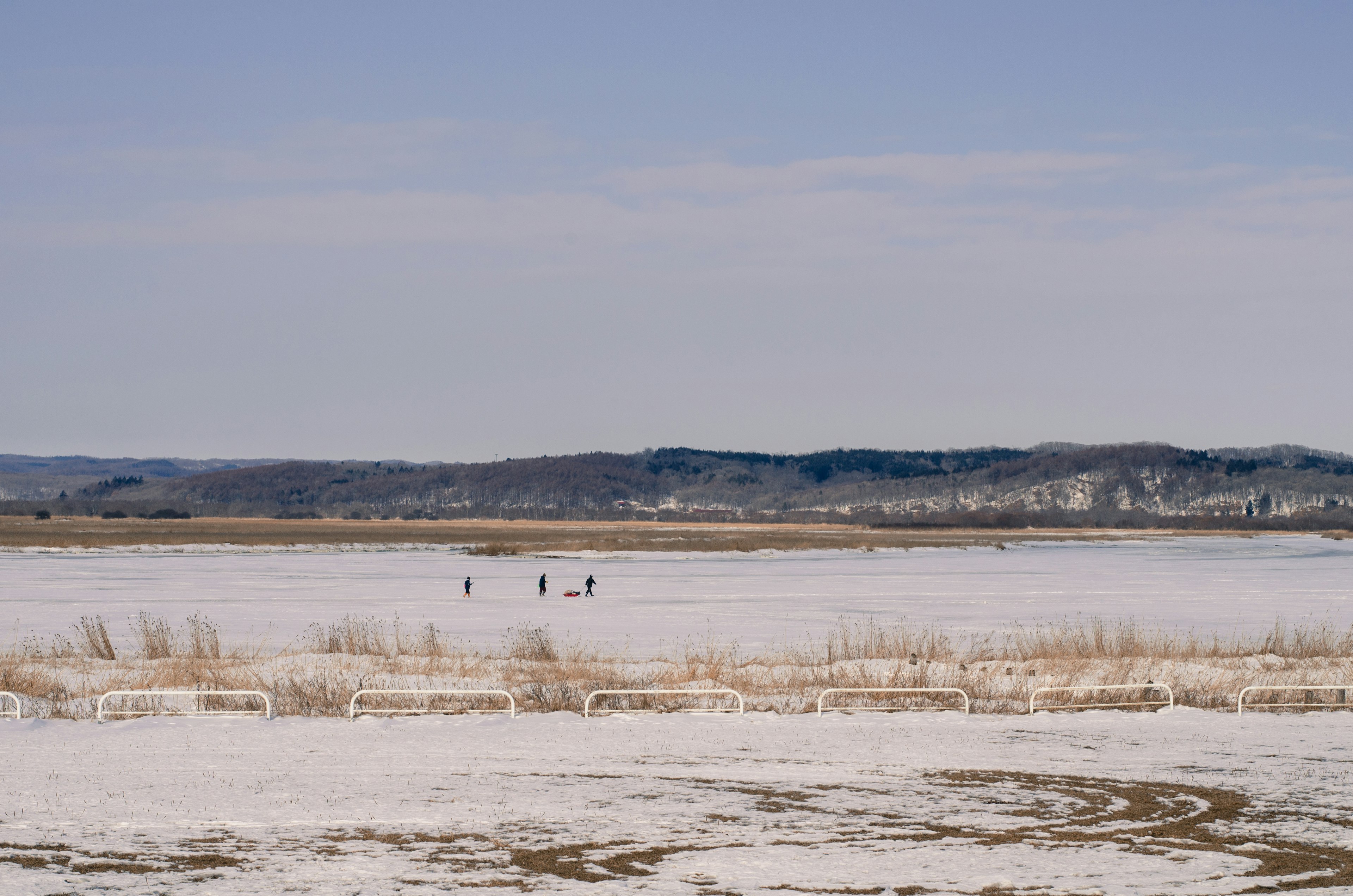 Snow-covered landscape with several people in the distance