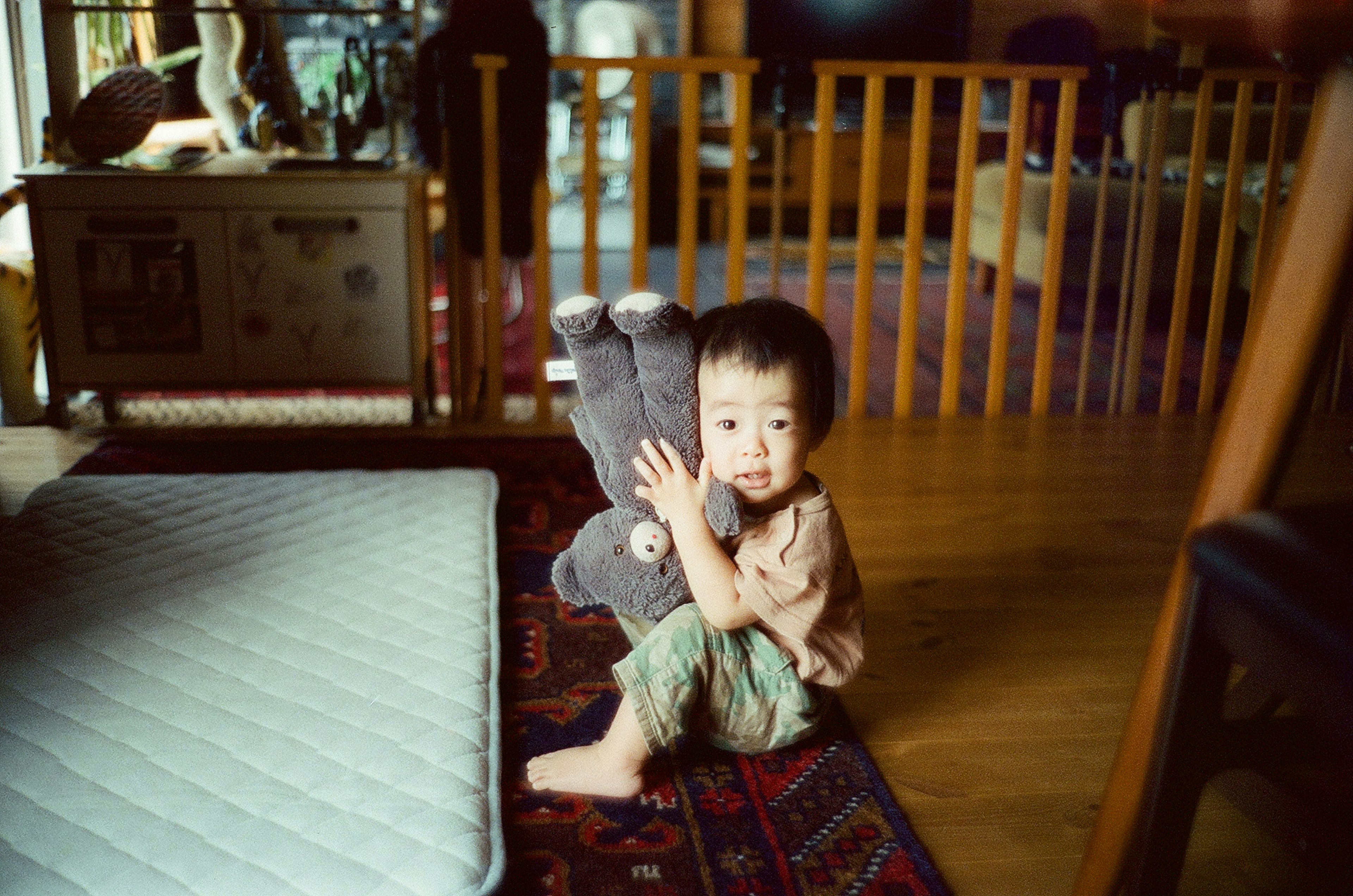 Un enfant serrant un ours en peluche dans un cadre intérieur confortable