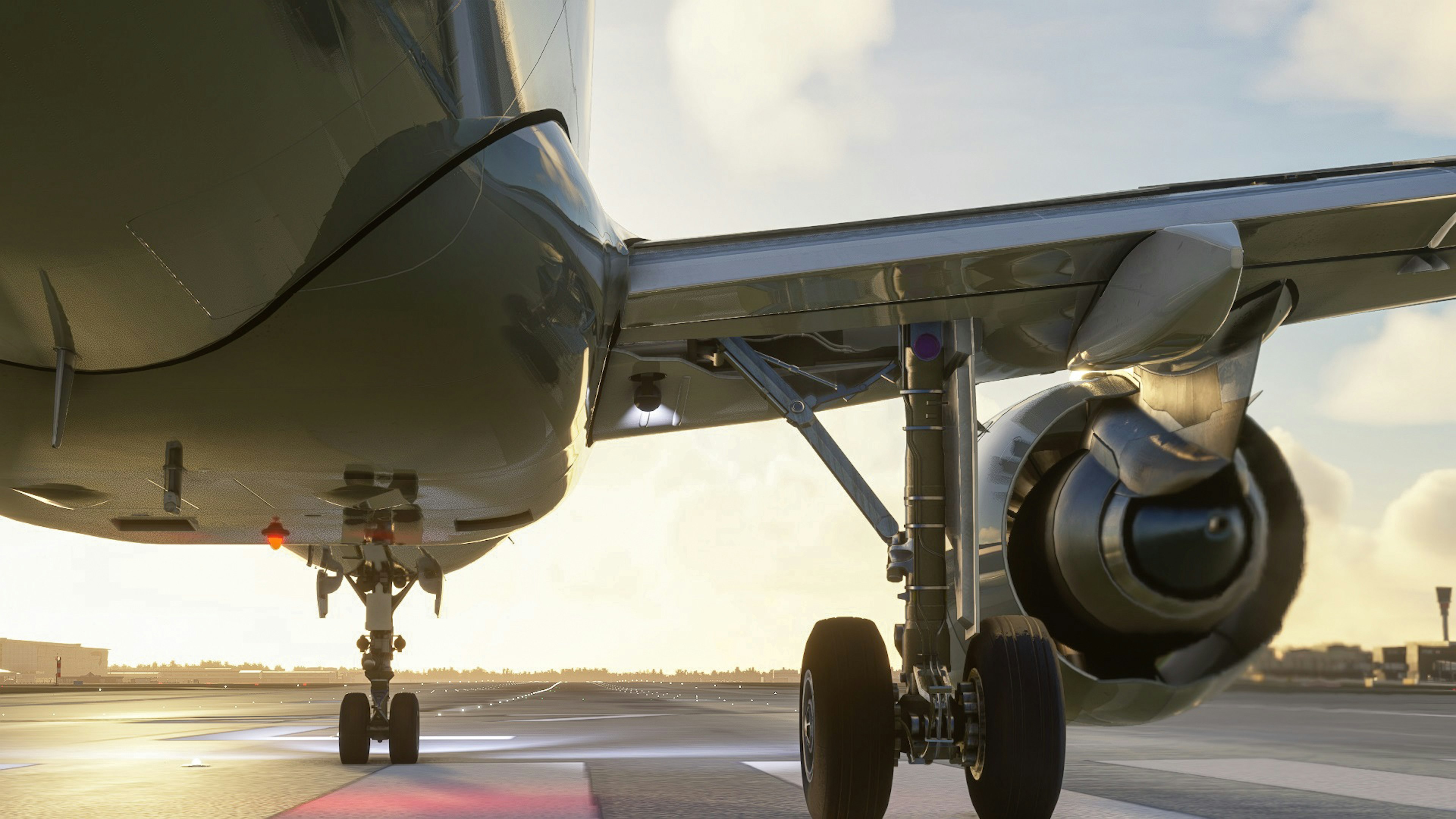 Close-up of an airplane's engine and landing gear on an airport runway