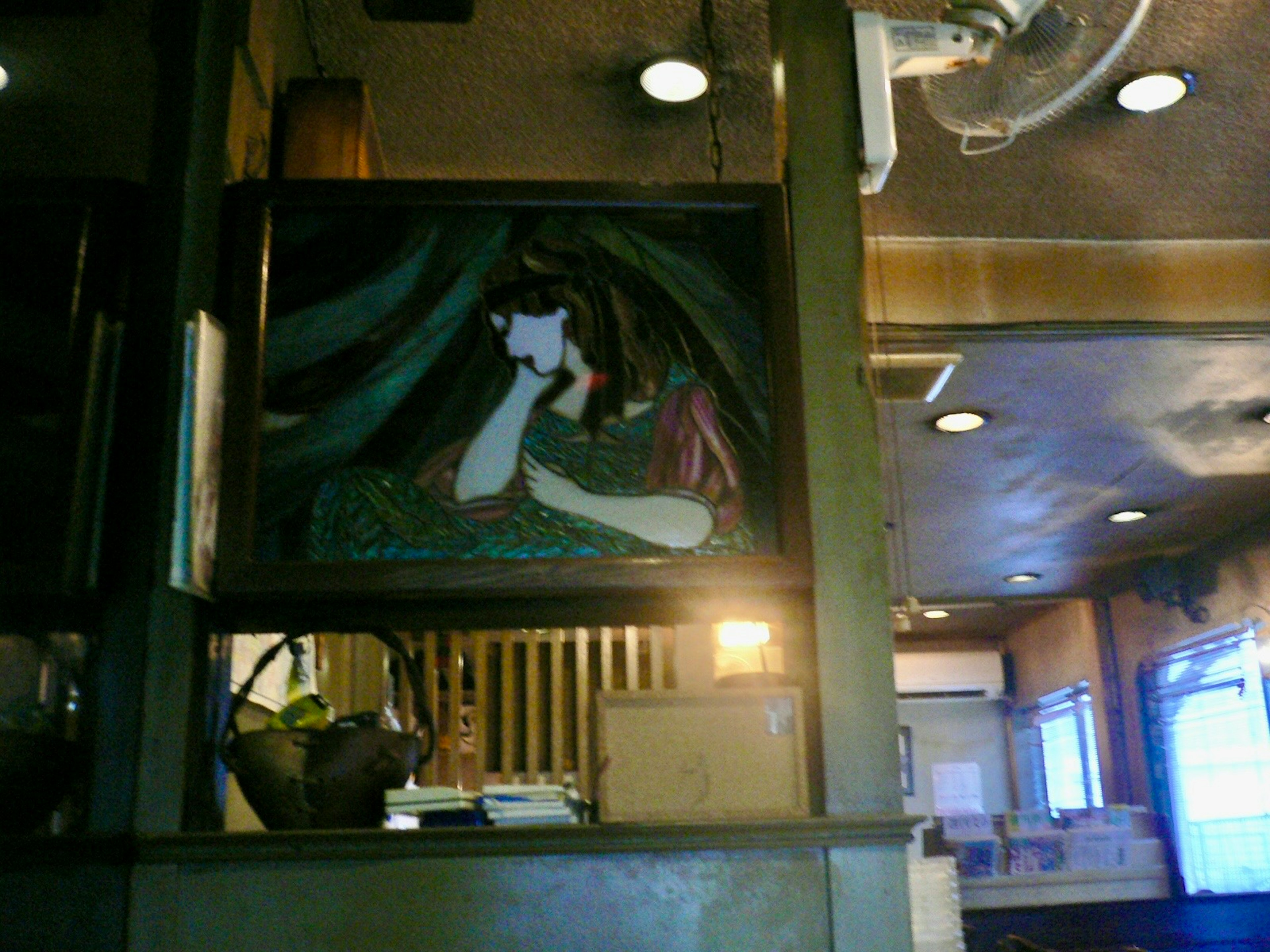 Interior of a café featuring an artwork with a woman's face depicted in a painting