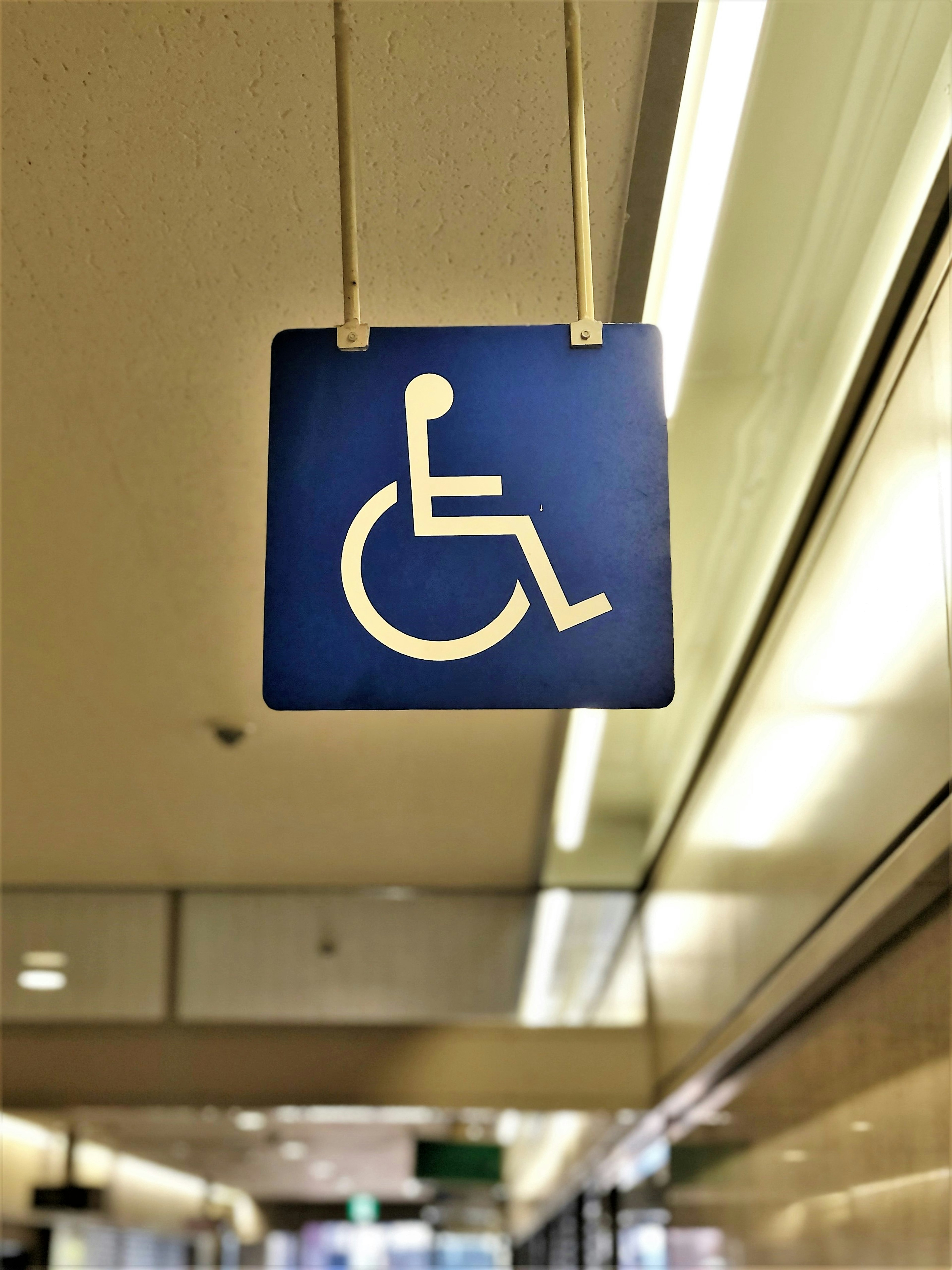 Panneau bleu avec symbole de fauteuil roulant blanc indiquant l'accessibilité