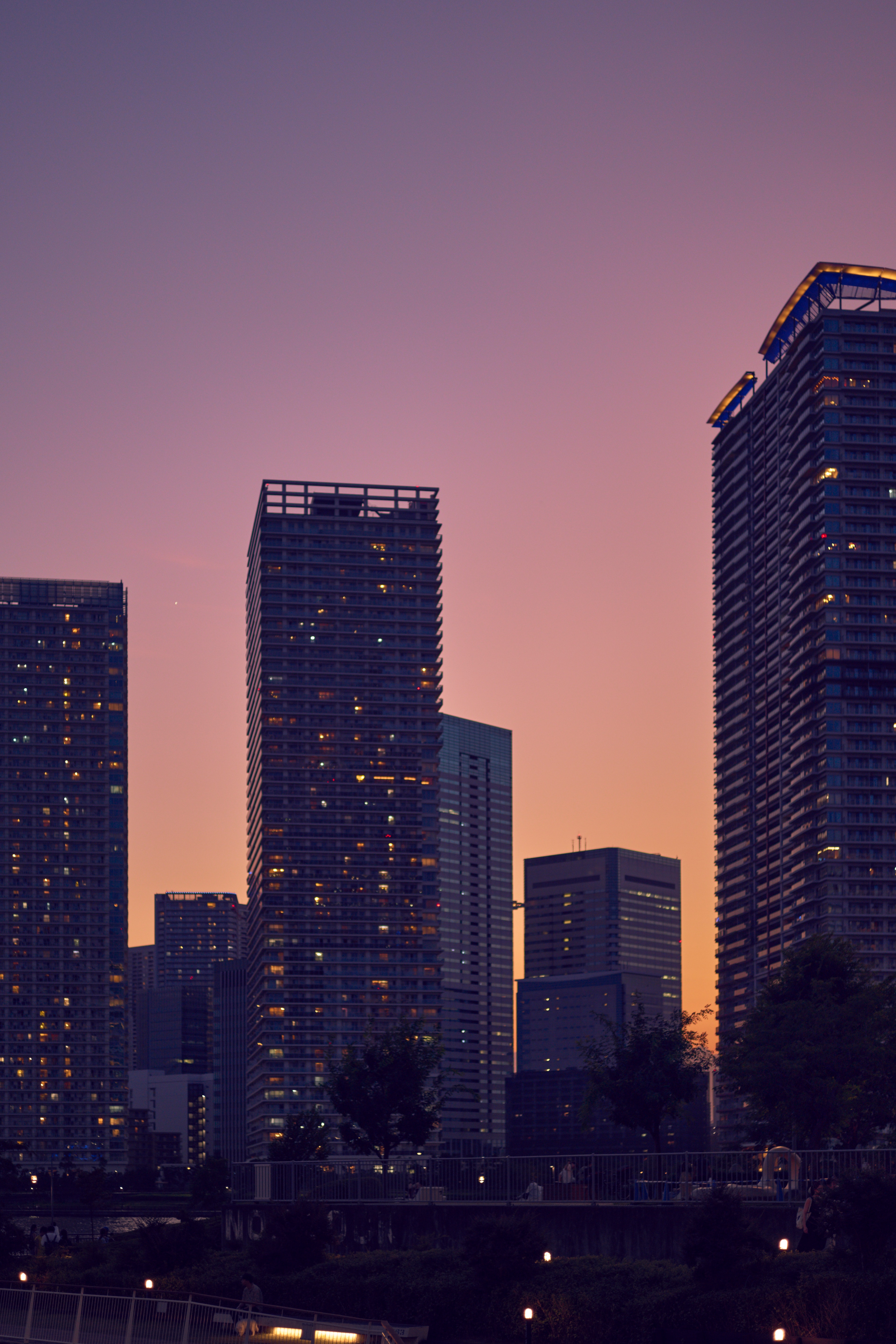 City skyline at dusk with tall buildings and orange sky