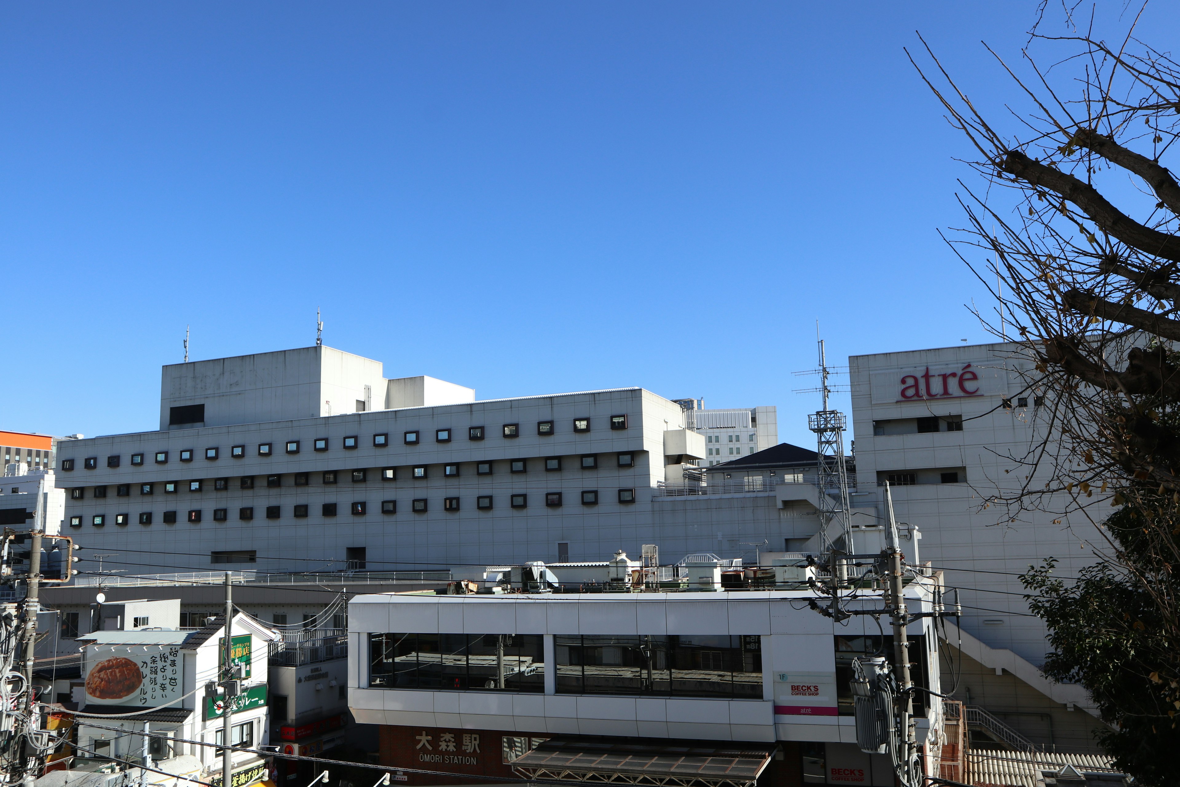 青空の下にある白い建物とその周辺の構造物