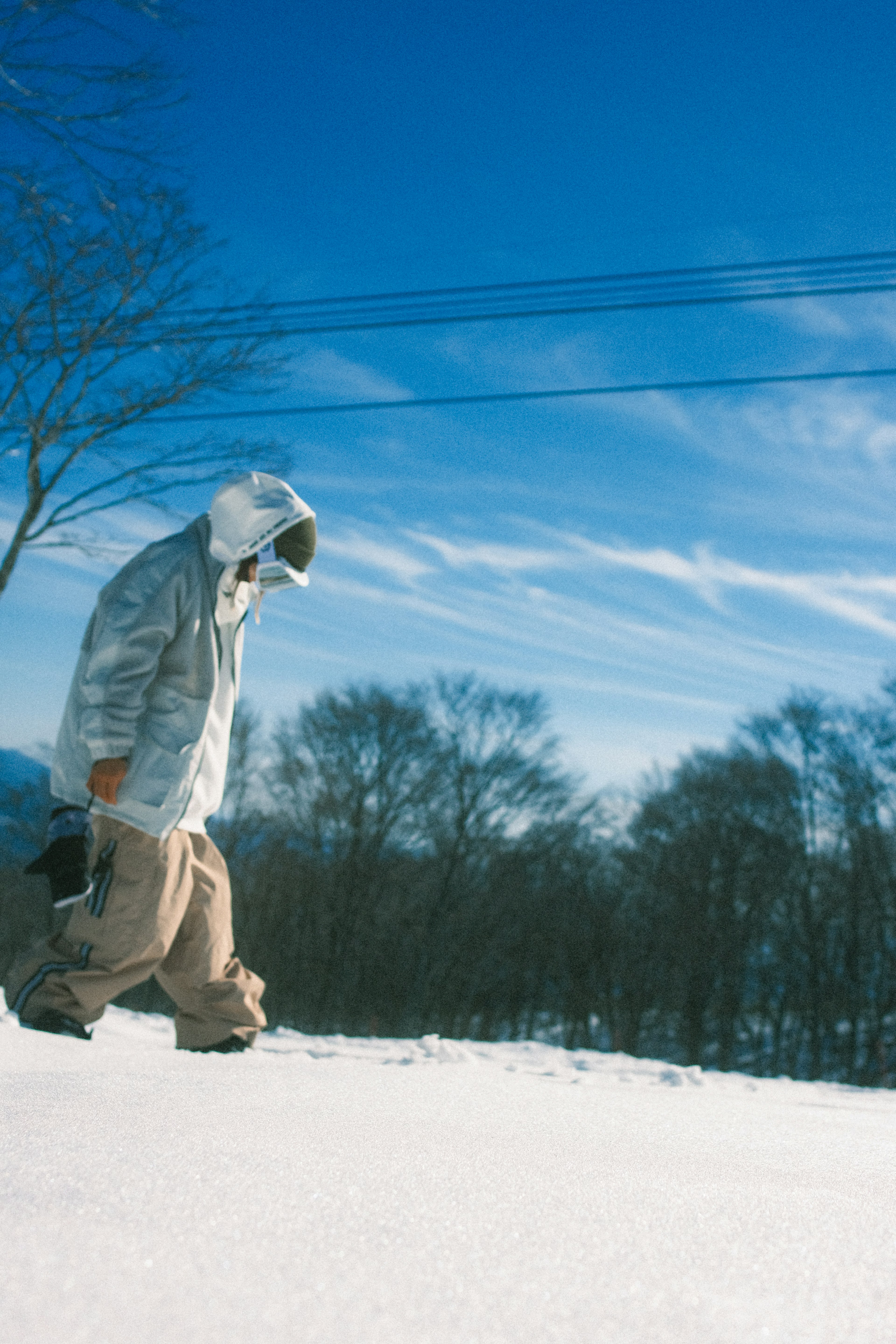 雪の上を歩く人物と青い空の風景