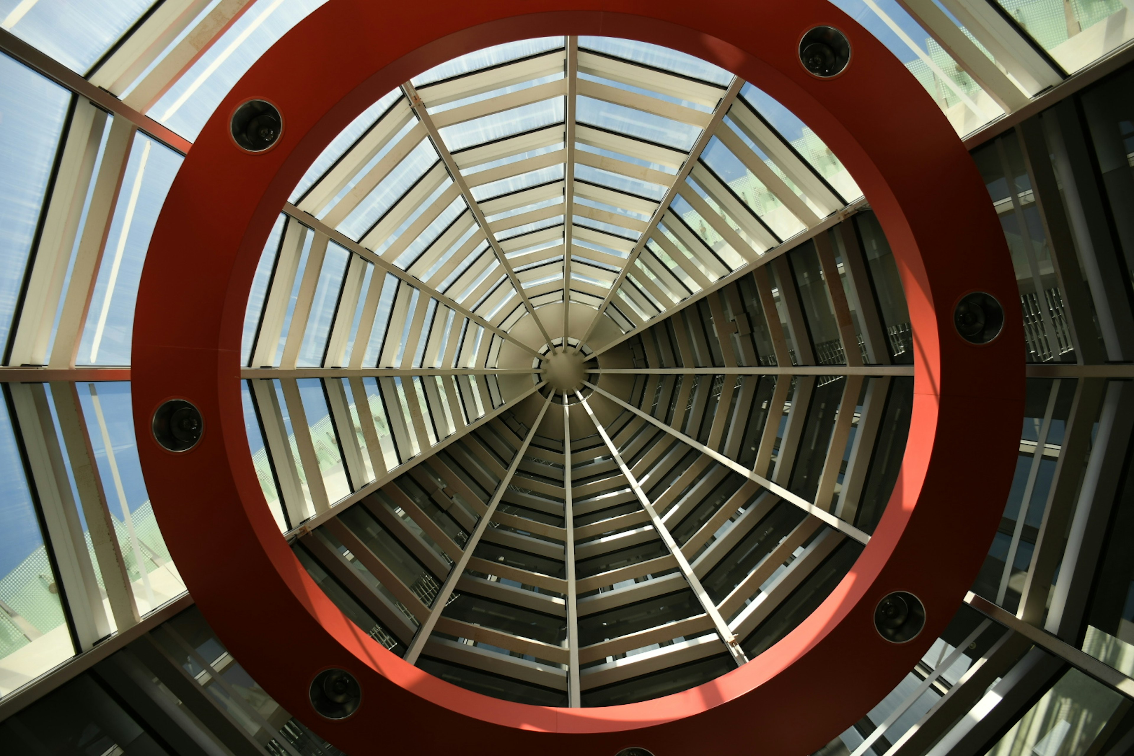 Interior view of a building featuring a red circular frame and glass ceiling