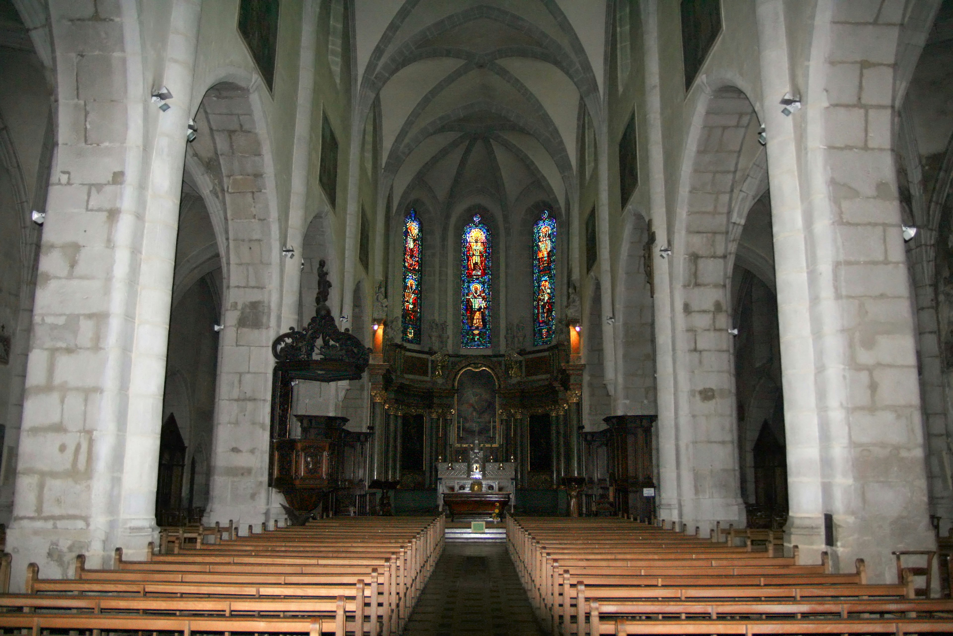 Geräumiges Innere einer Kirche mit schönen Buntglasfenstern und hohen gewölbten Decken