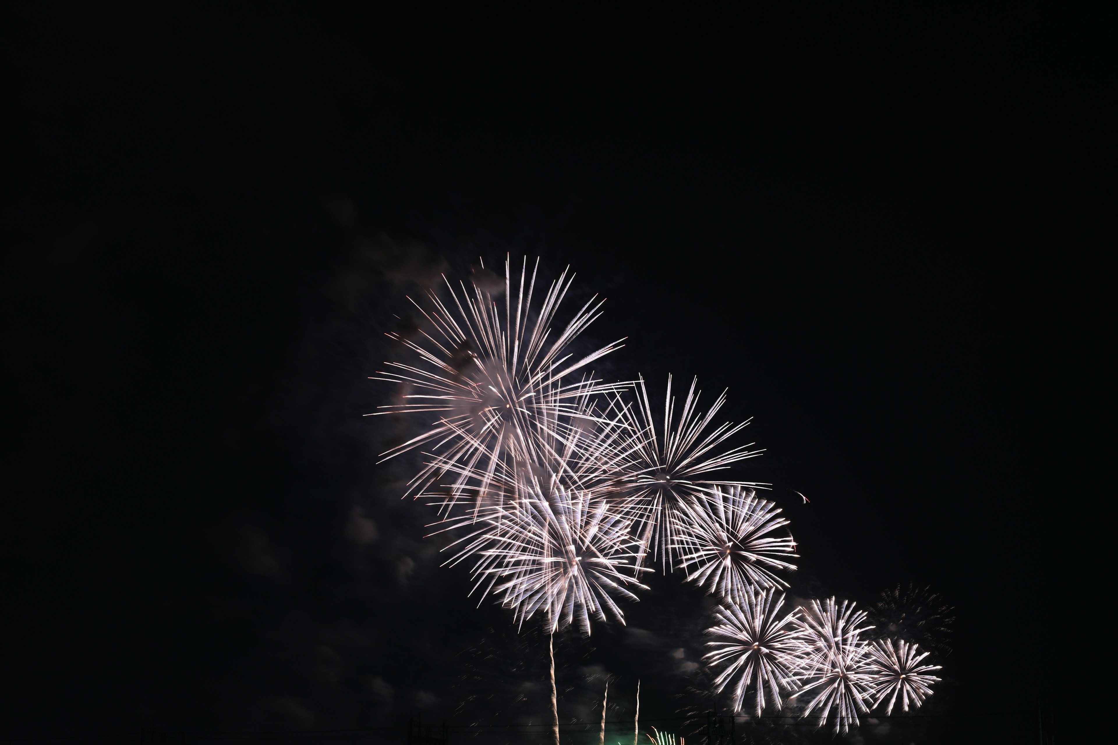 Éclats blancs ressemblant à des feux d'artifice dans le ciel nocturne