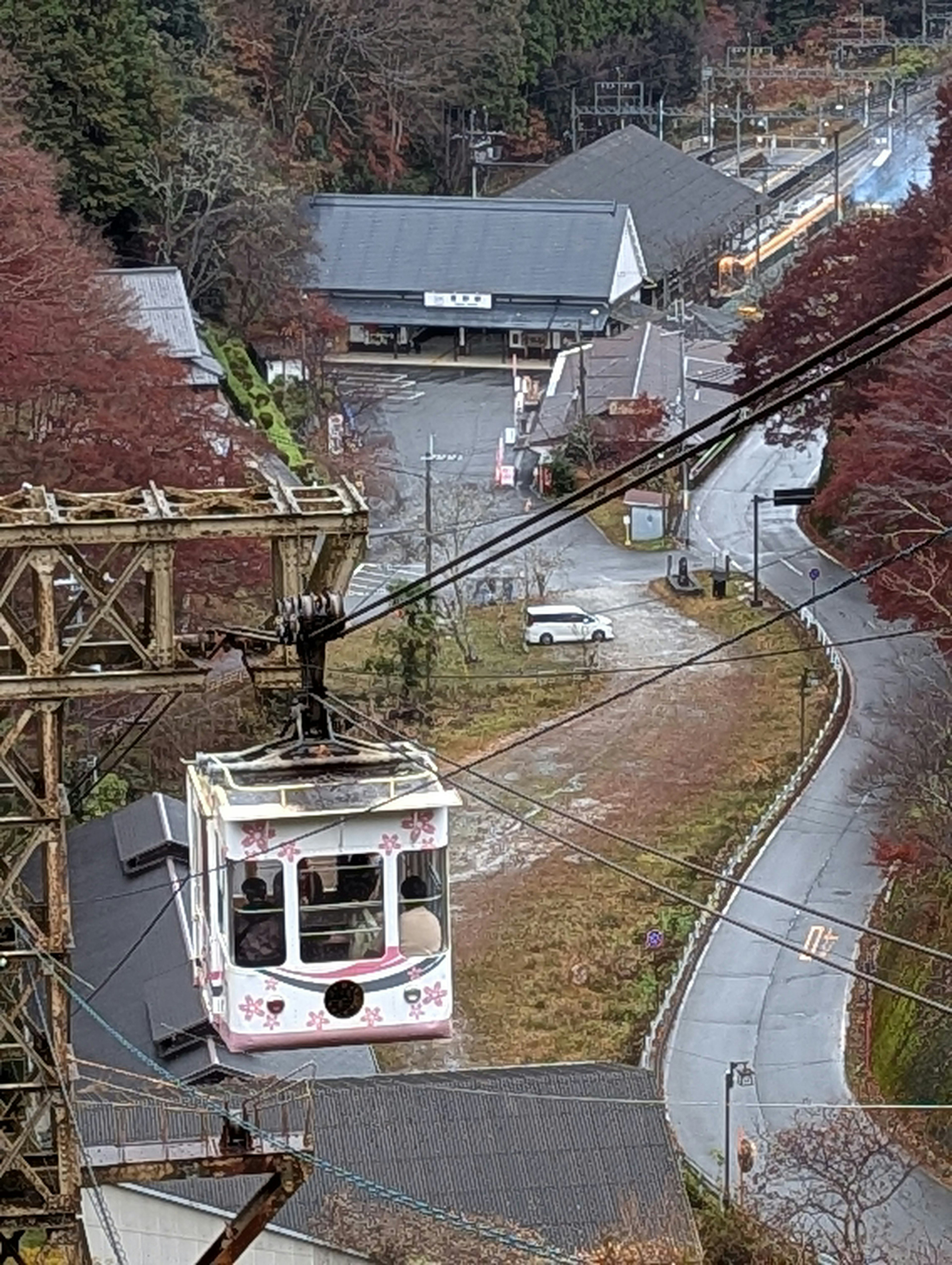 Eine Seilbahn, die einen Berghang hinauffährt, umgeben von lebhaftem Herbstlaub