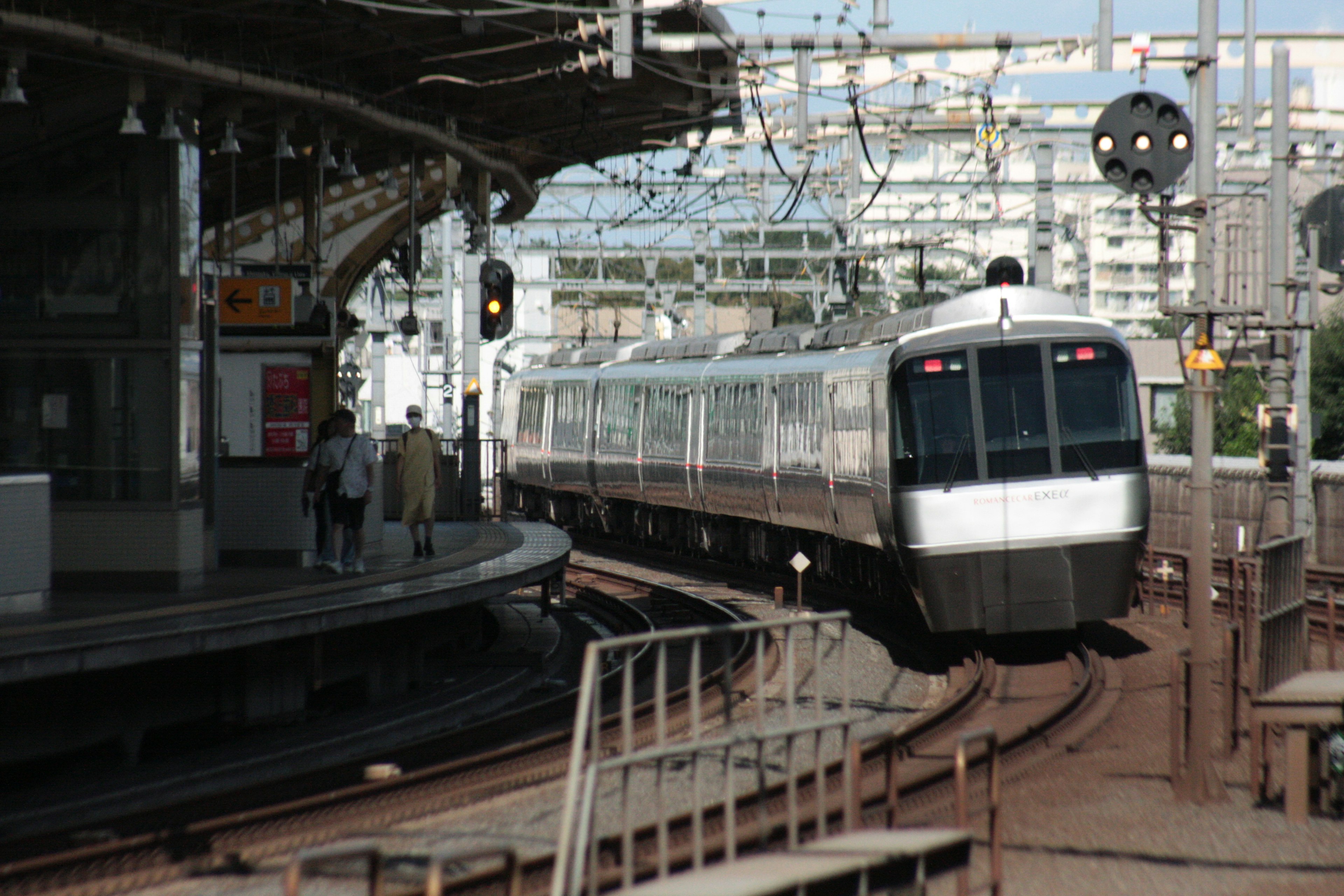 รถไฟสีเงินกำลังเข้าใกล้สถานีในขณะเลี้ยวโค้ง