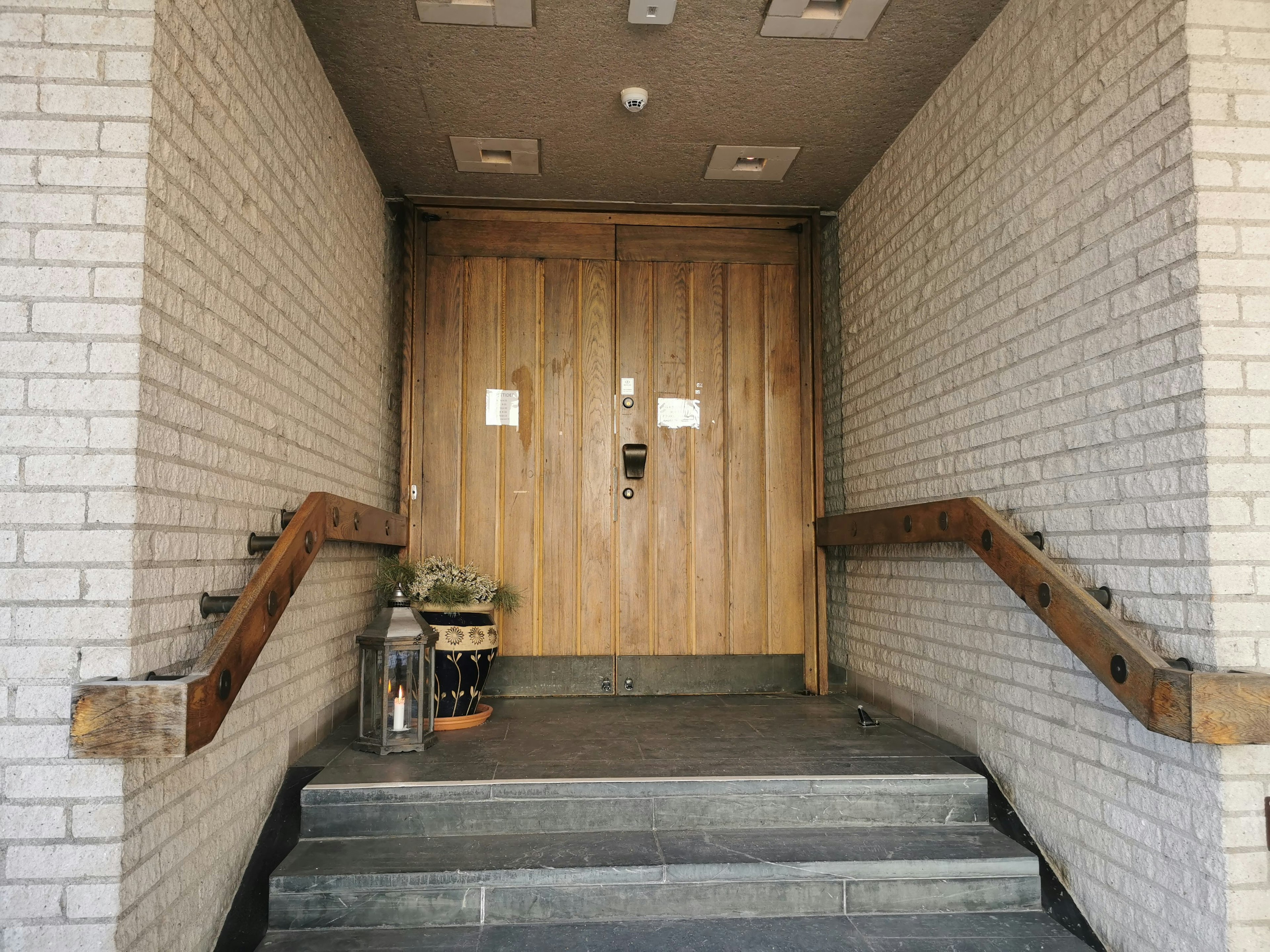 Entrance with wooden door and brick walls leading to stone steps