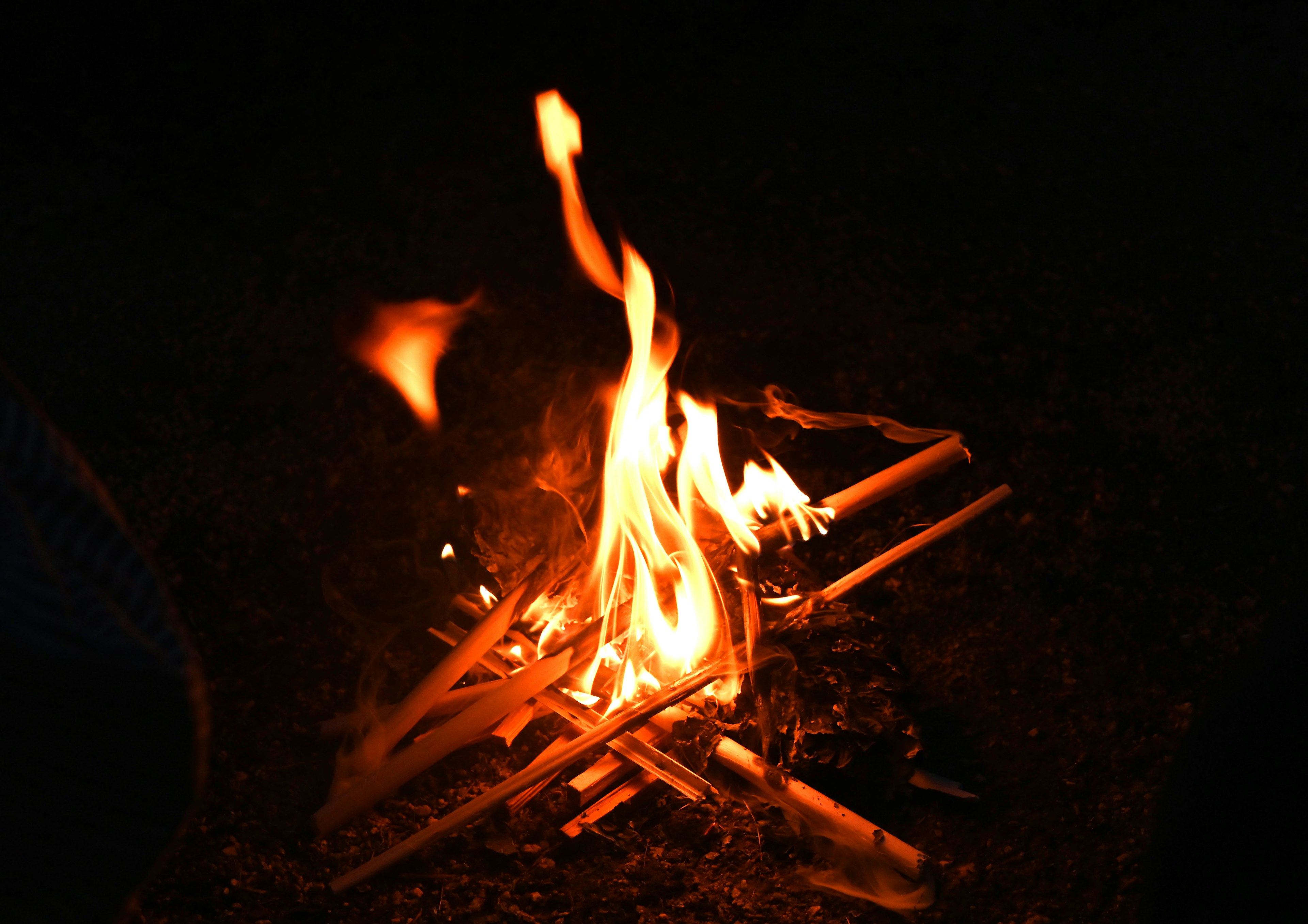 Llamas de fogata y madera ardiendo en la oscuridad