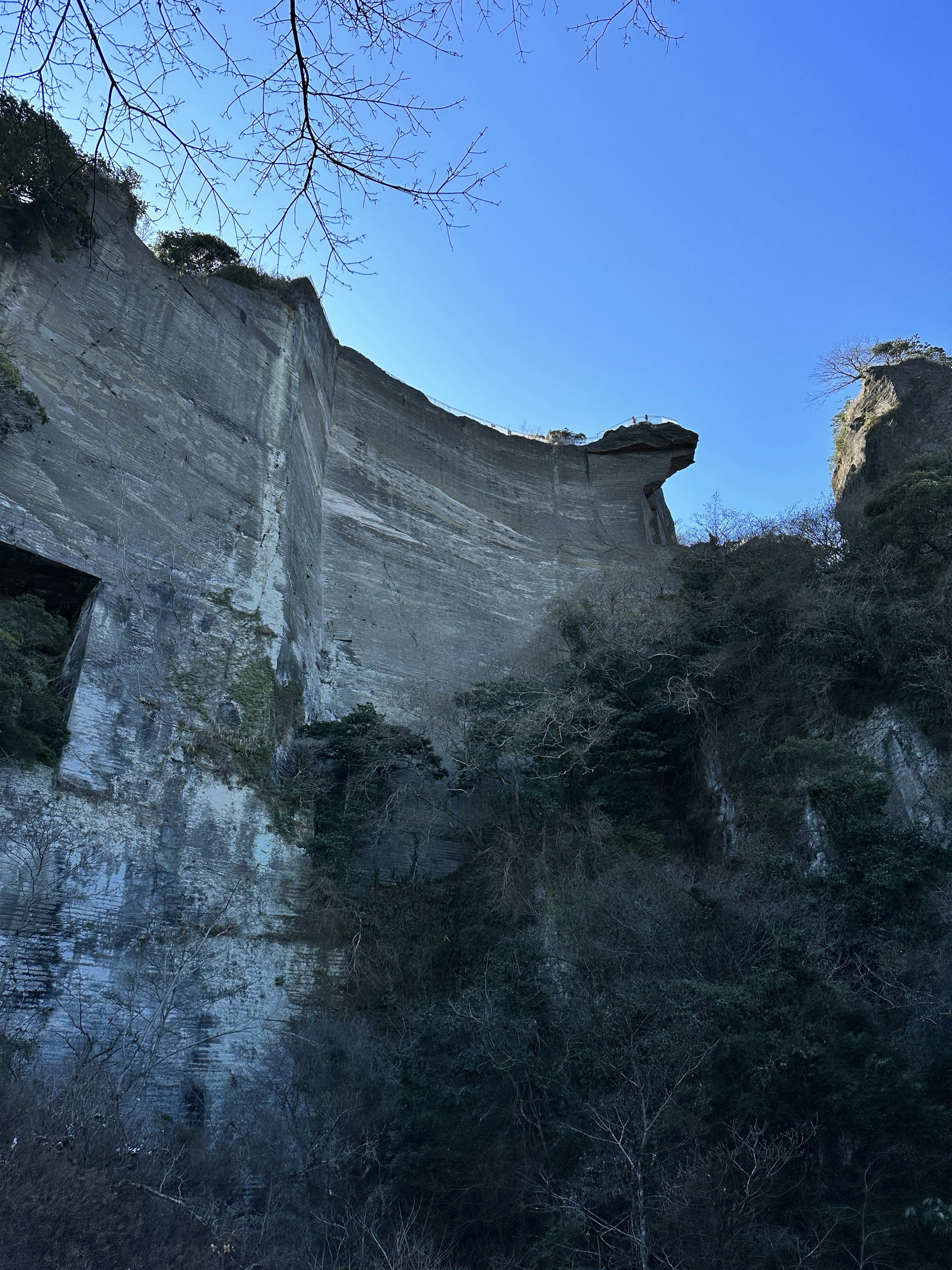 Struttura in cemento simile a una scogliera sotto un cielo blu chiaro