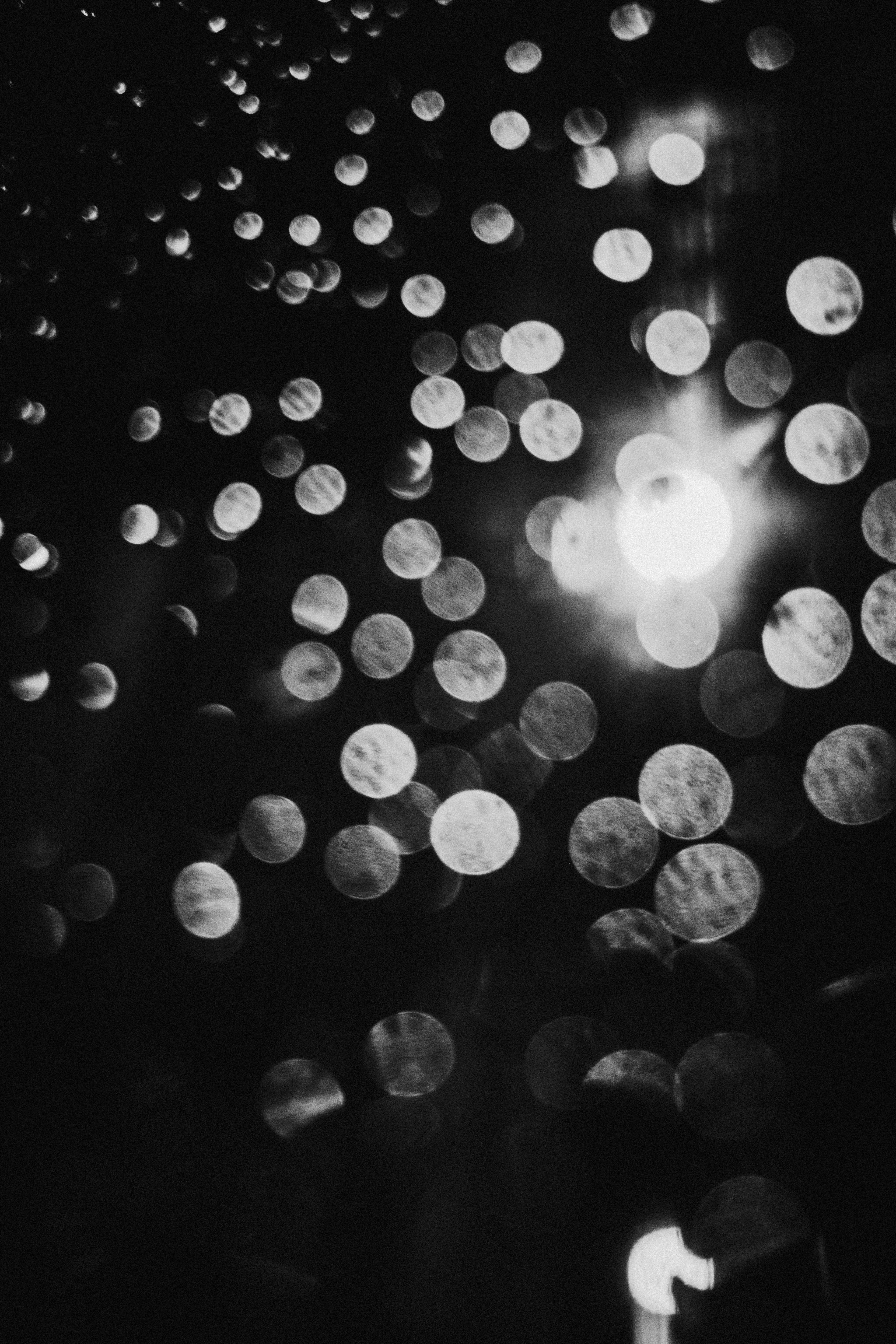 Abstract image of blurred light spots scattered against a black and white background