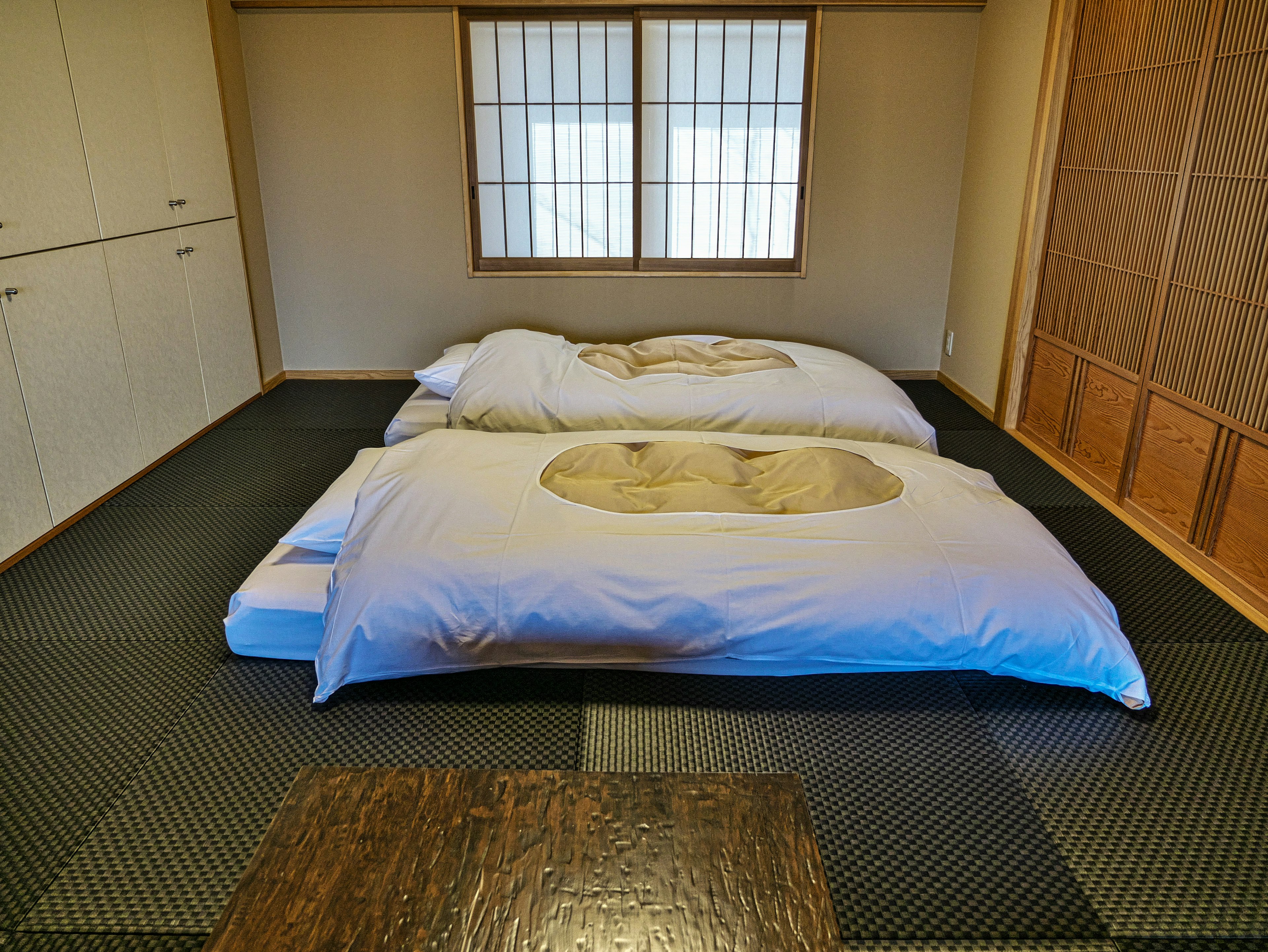 Chambre simple avec des futons sur un sol en tatami