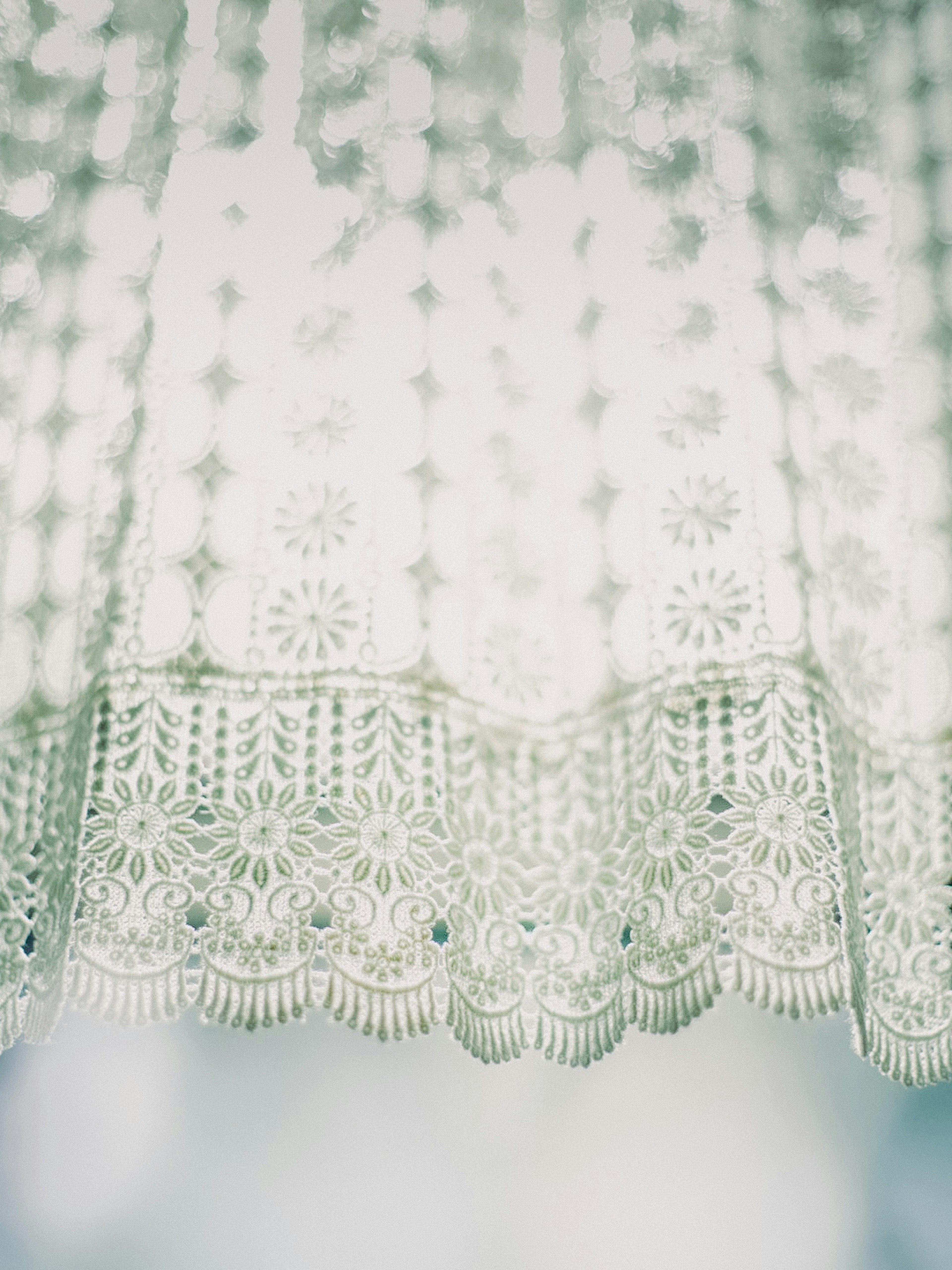 Detailed design and translucence of a white lace curtain