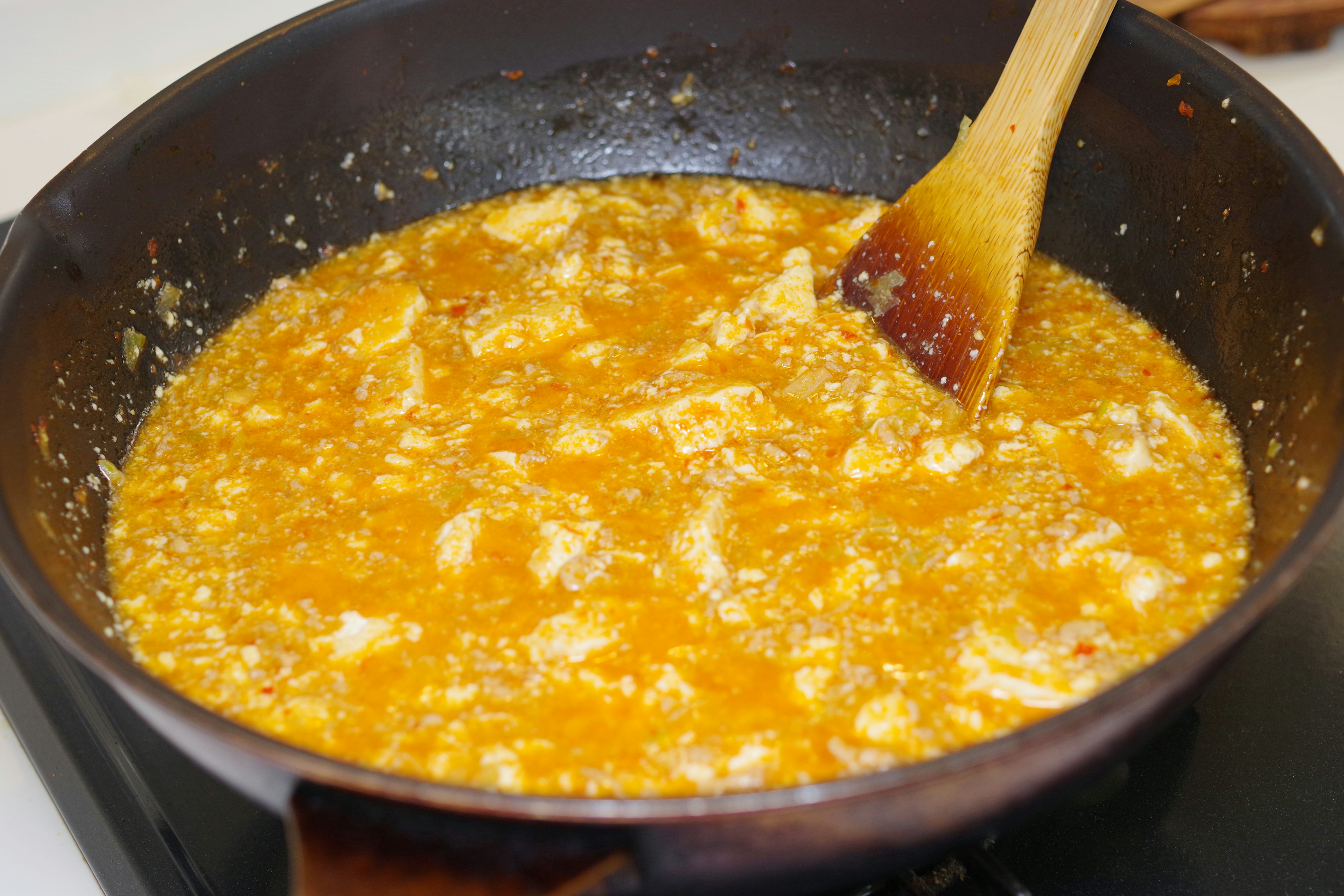 Cooked orange sauce with chicken in a frying pan